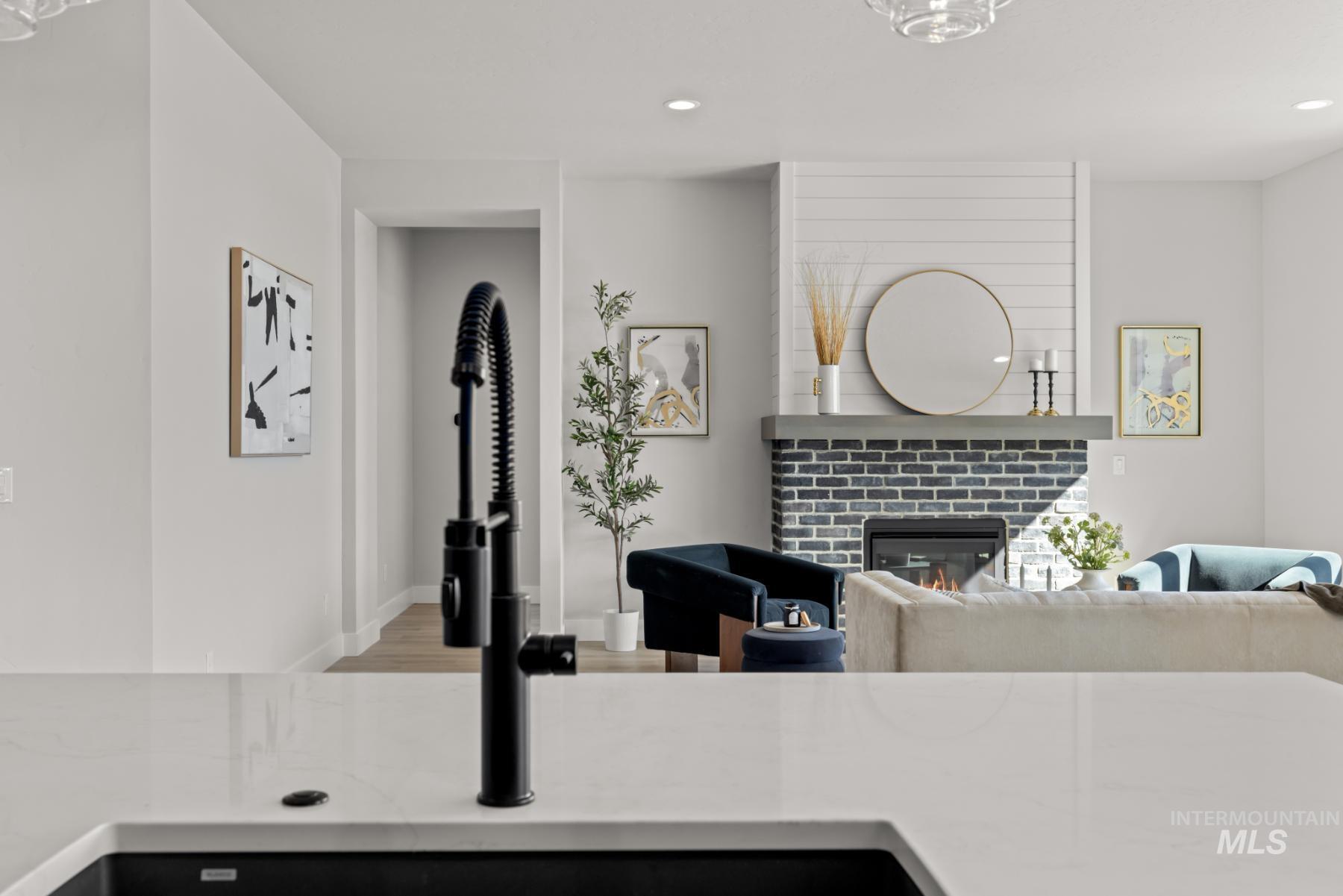 Living room featuring a glass covered fireplace, light wood-style floors, and recessed lighting
