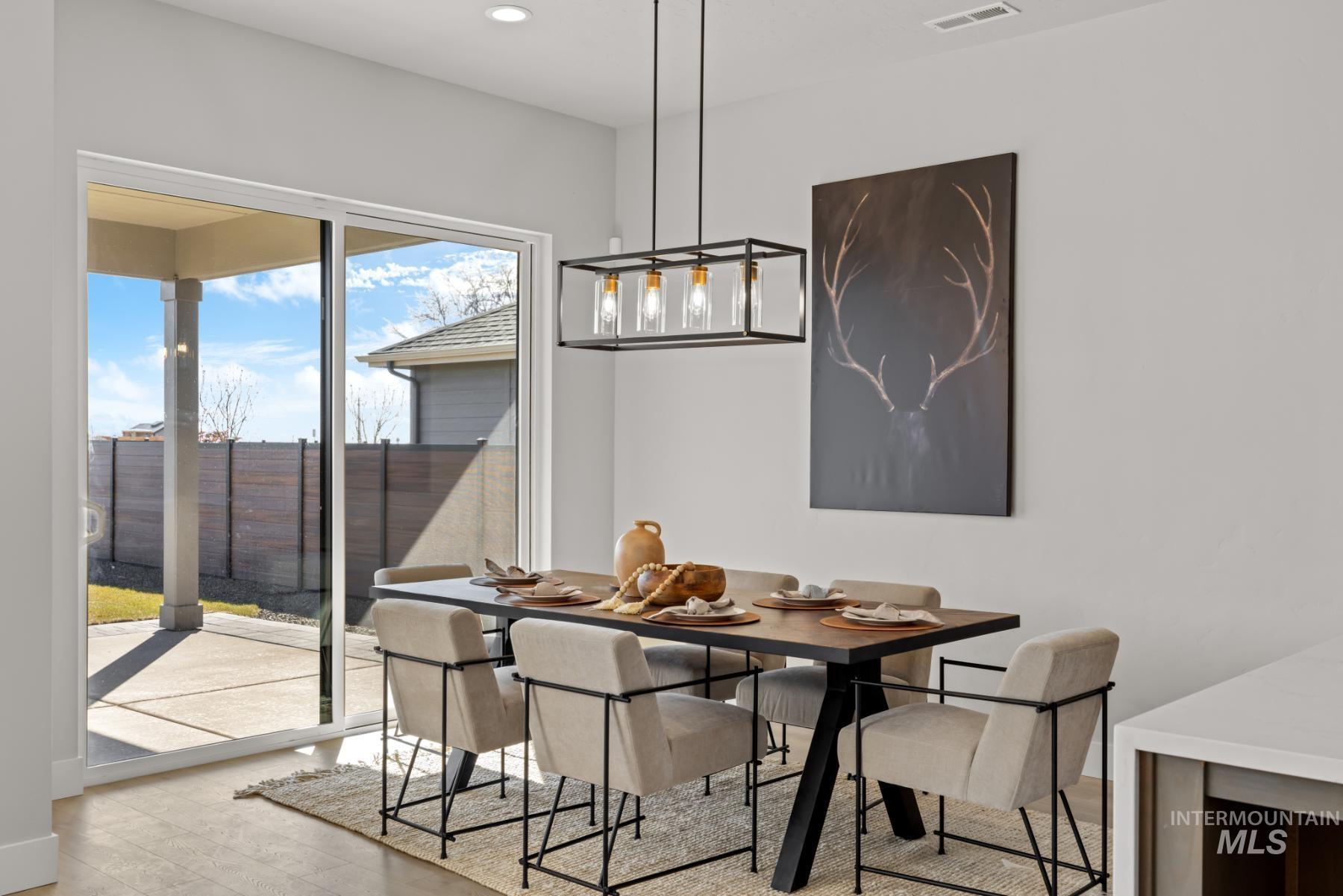 Dining room with light wood-type flooring and recessed lighting