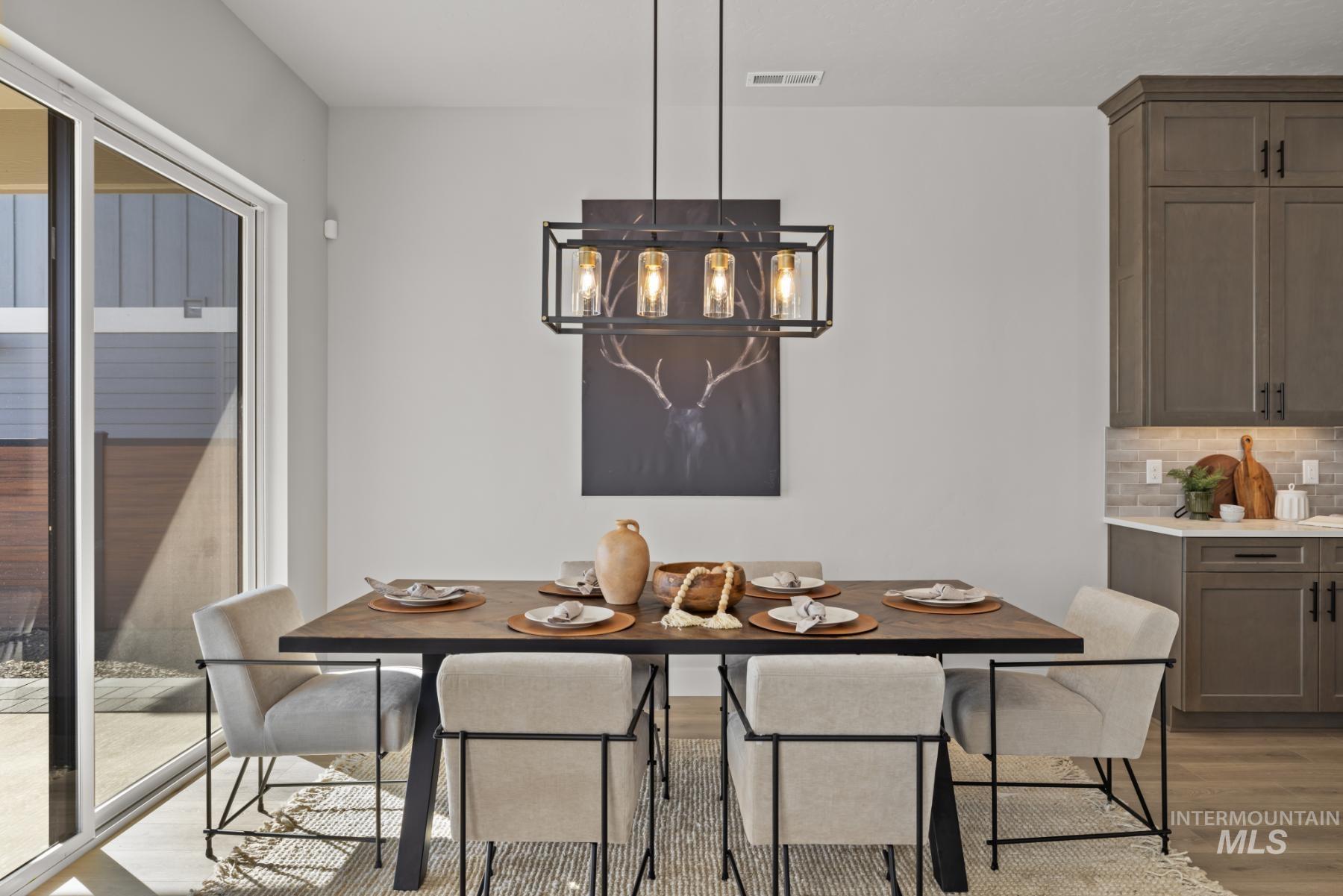 Dining area with light wood-type flooring and a chandelier