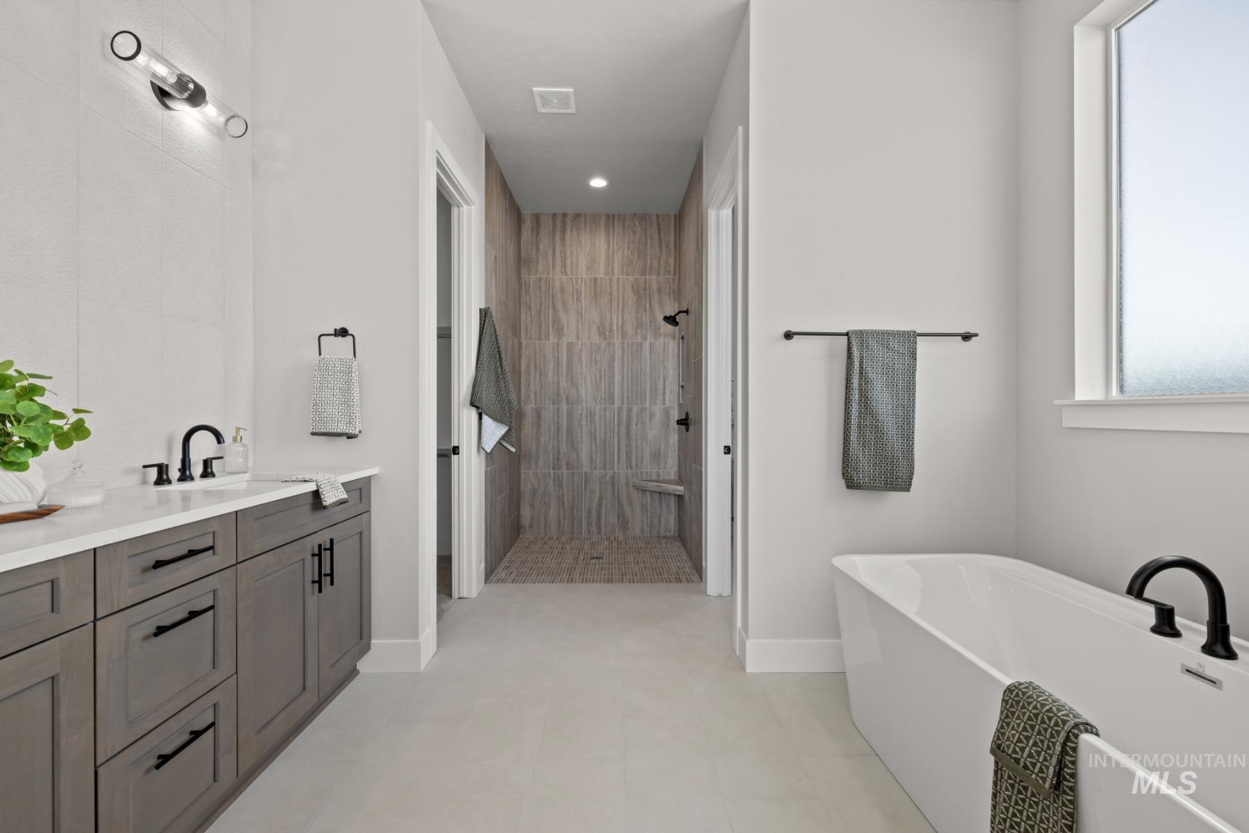 Bathroom with walk in shower, a soaking tub, vanity, and recessed lighting