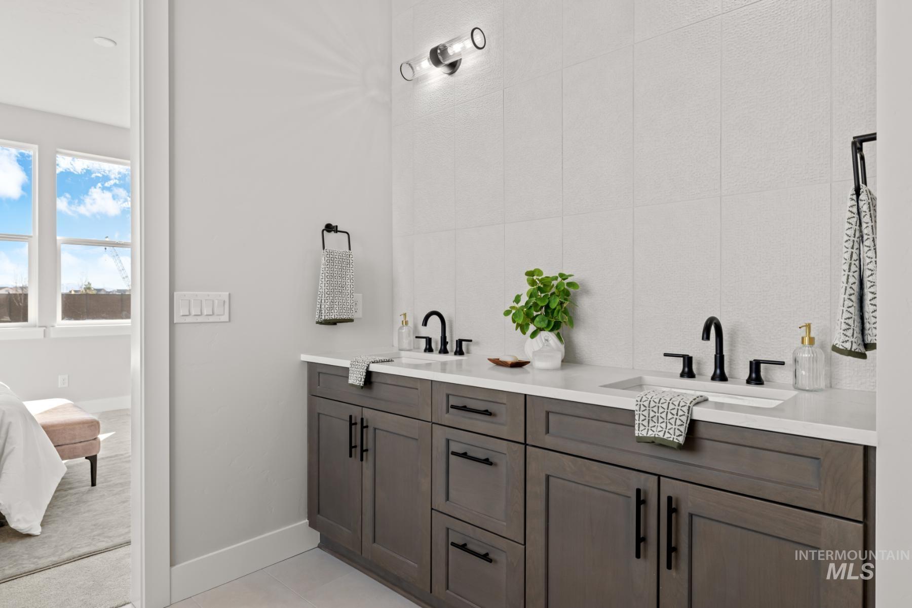 Ensuite bathroom with double vanity and baseboards