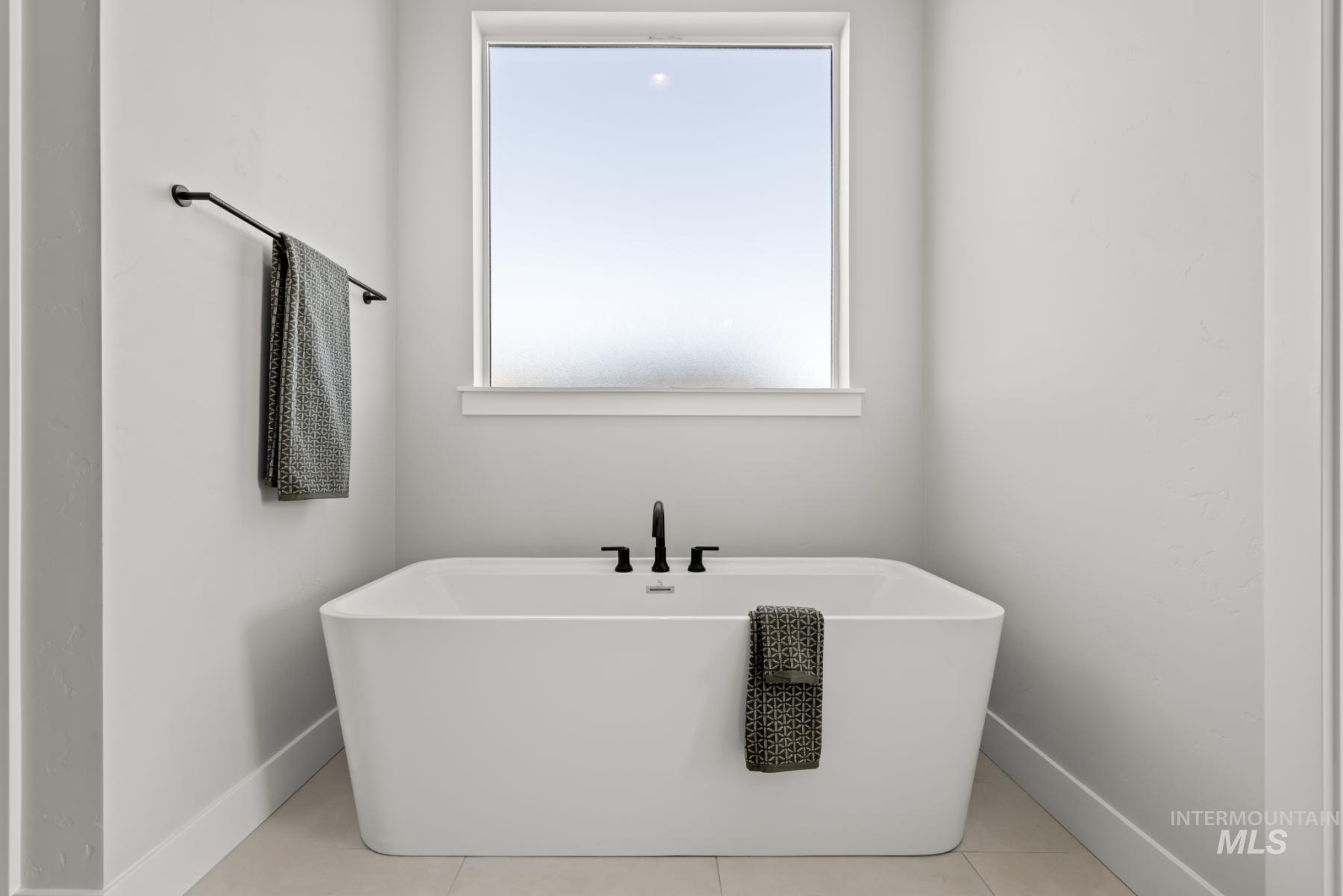 Full bathroom featuring a freestanding tub and tile patterned floors