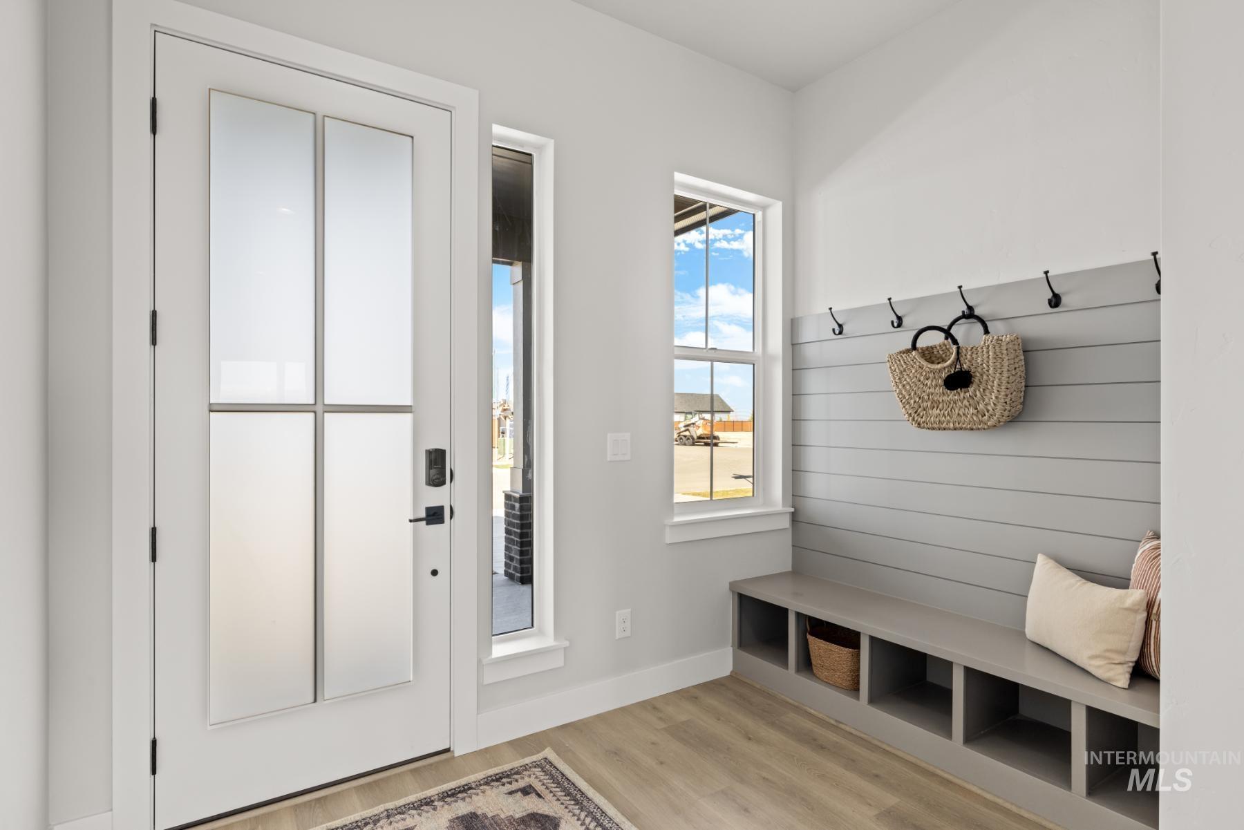 Mudroom featuring light wood-style floors and baseboards
