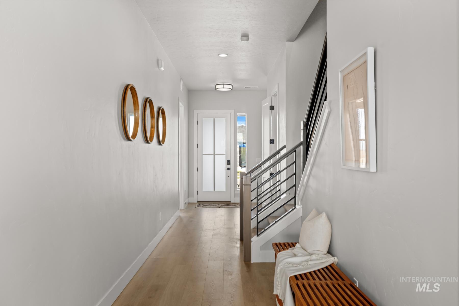 Hall with light wood-type flooring and stairs