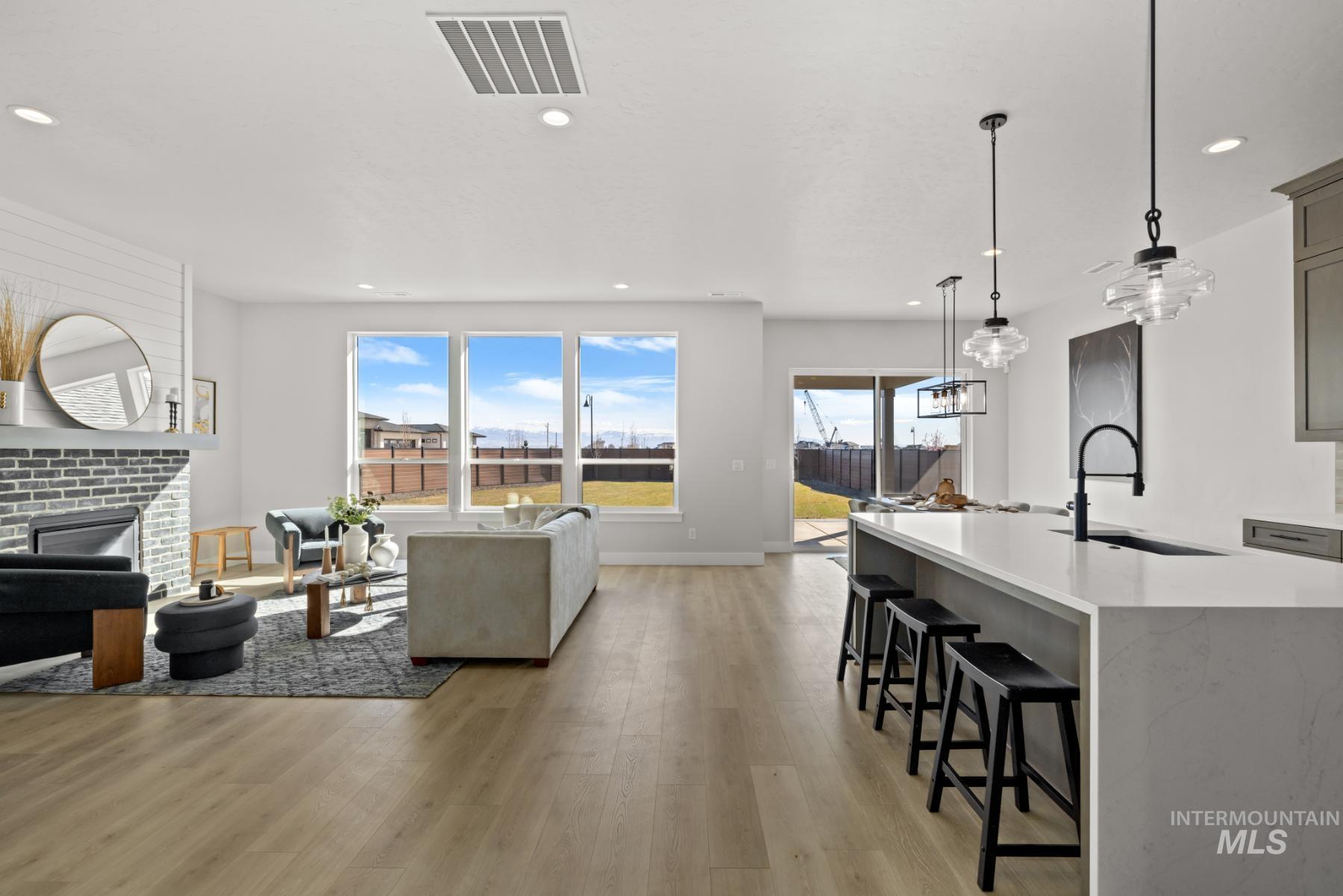 Living room featuring light wood-style flooring, a fireplace, and recessed lighting