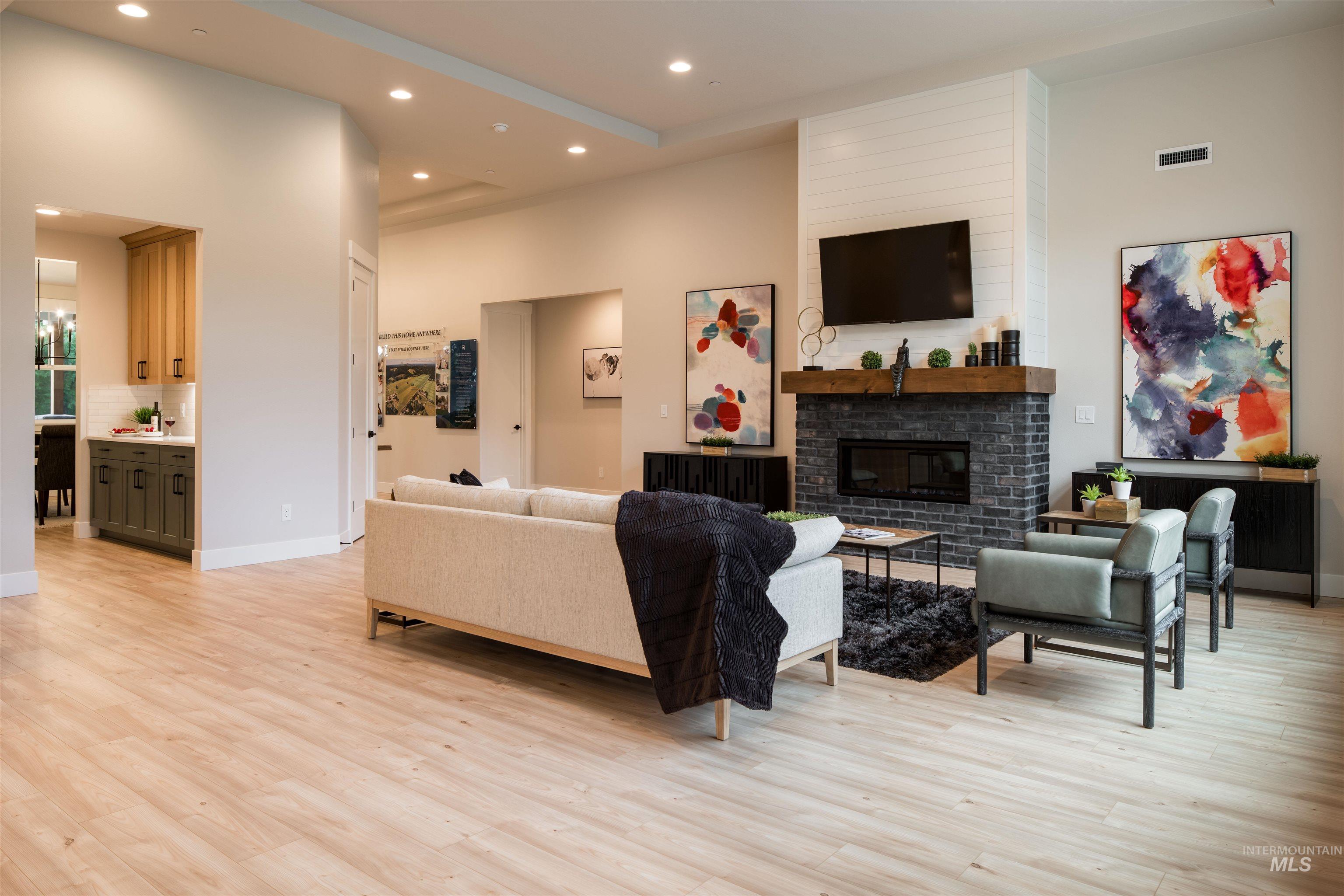 Living area featuring recessed lighting, light wood finished floors, and a fireplace