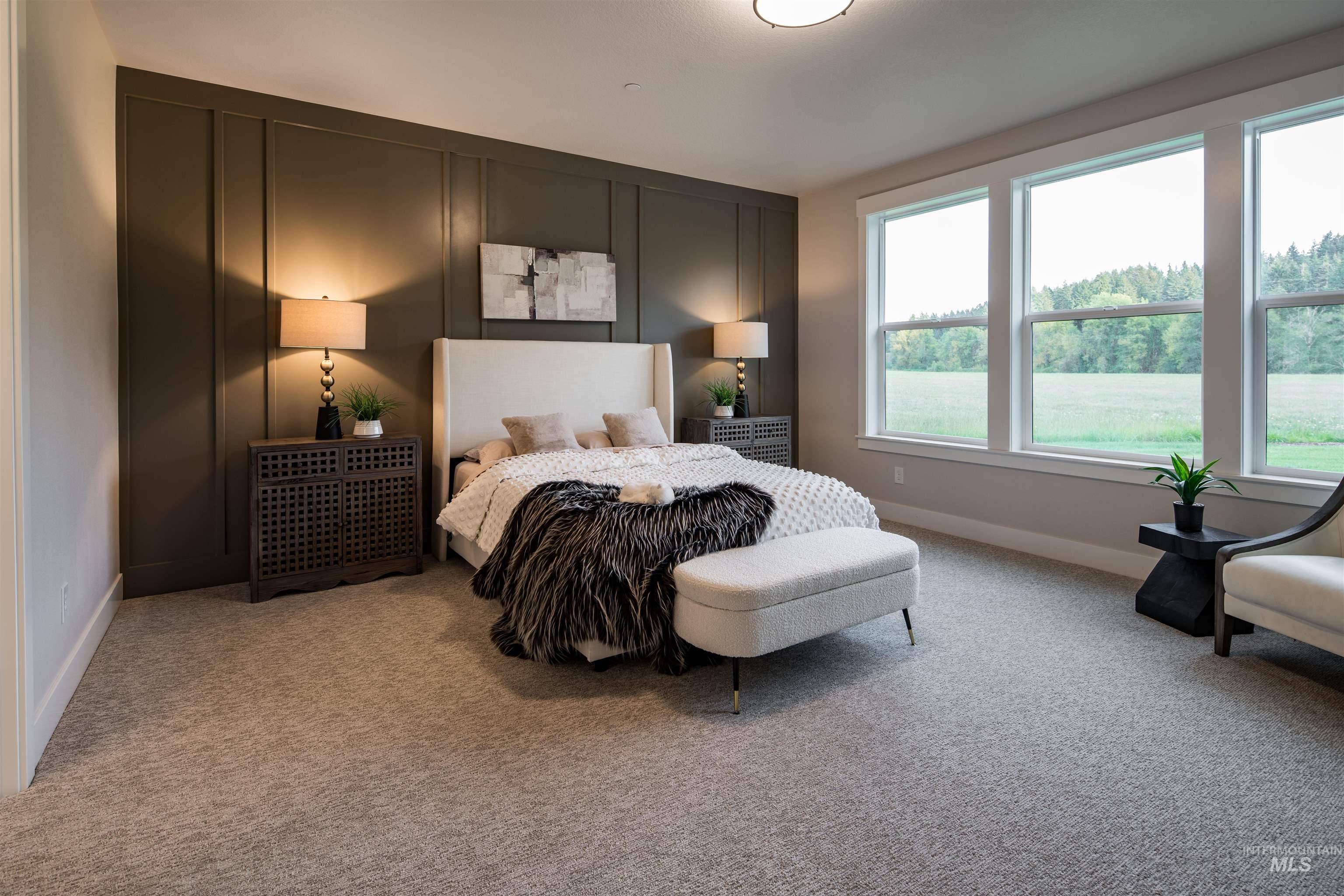 Bedroom featuring light colored carpet and a decorative wall