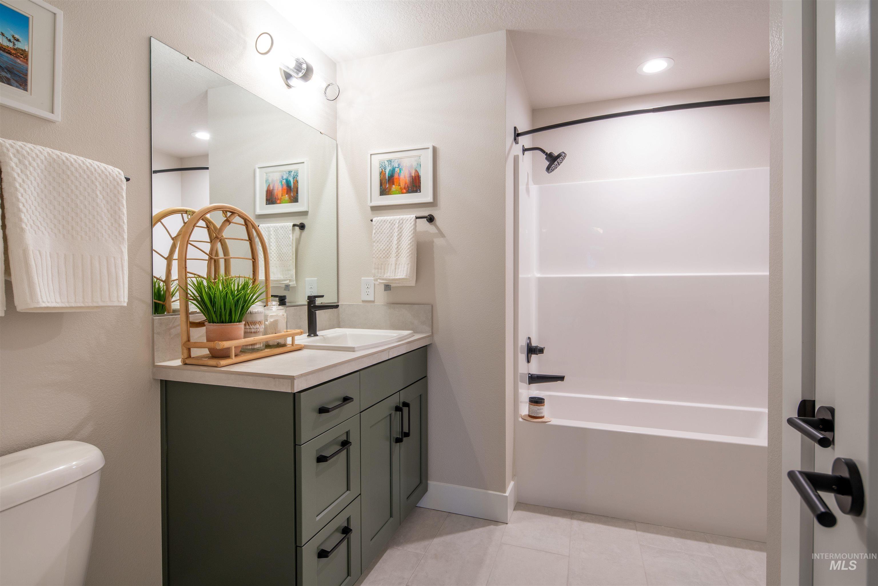 Full bathroom with vanity, shower / bath combination, light tile patterned floors, and recessed lighting