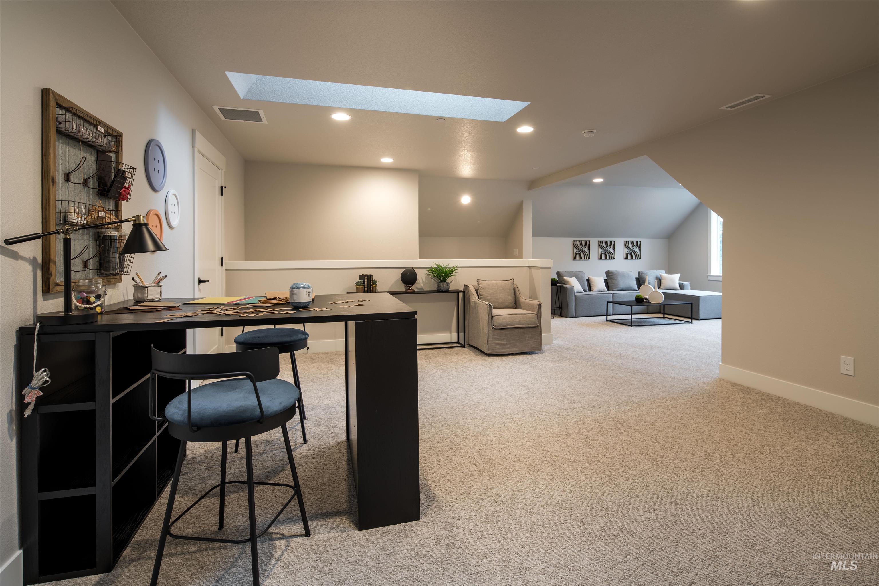 Office area featuring lofted ceiling, light colored carpet, recessed lighting, and a skylight