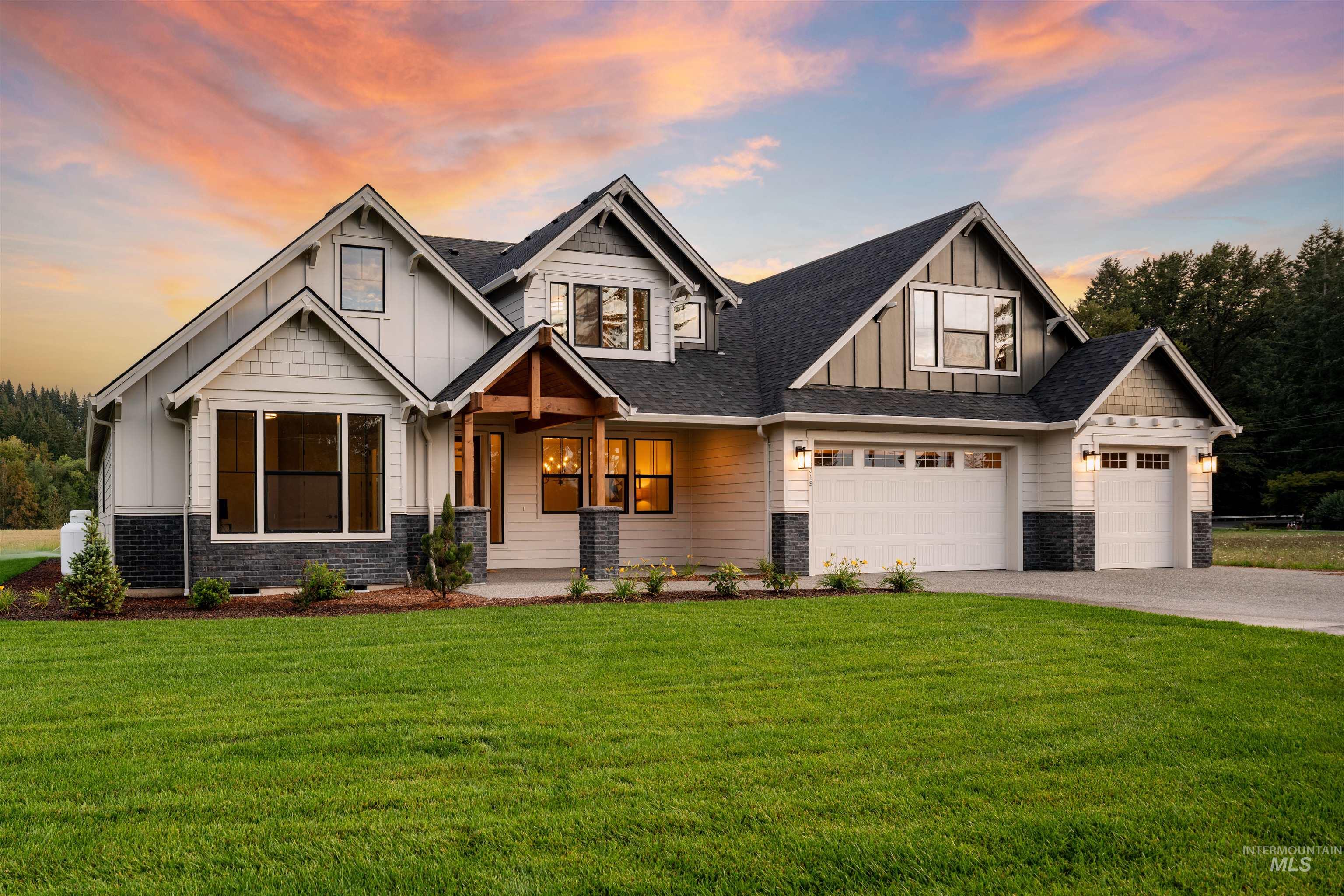 Craftsman-style home featuring board and batten siding, a front yard, driveway, and a porch