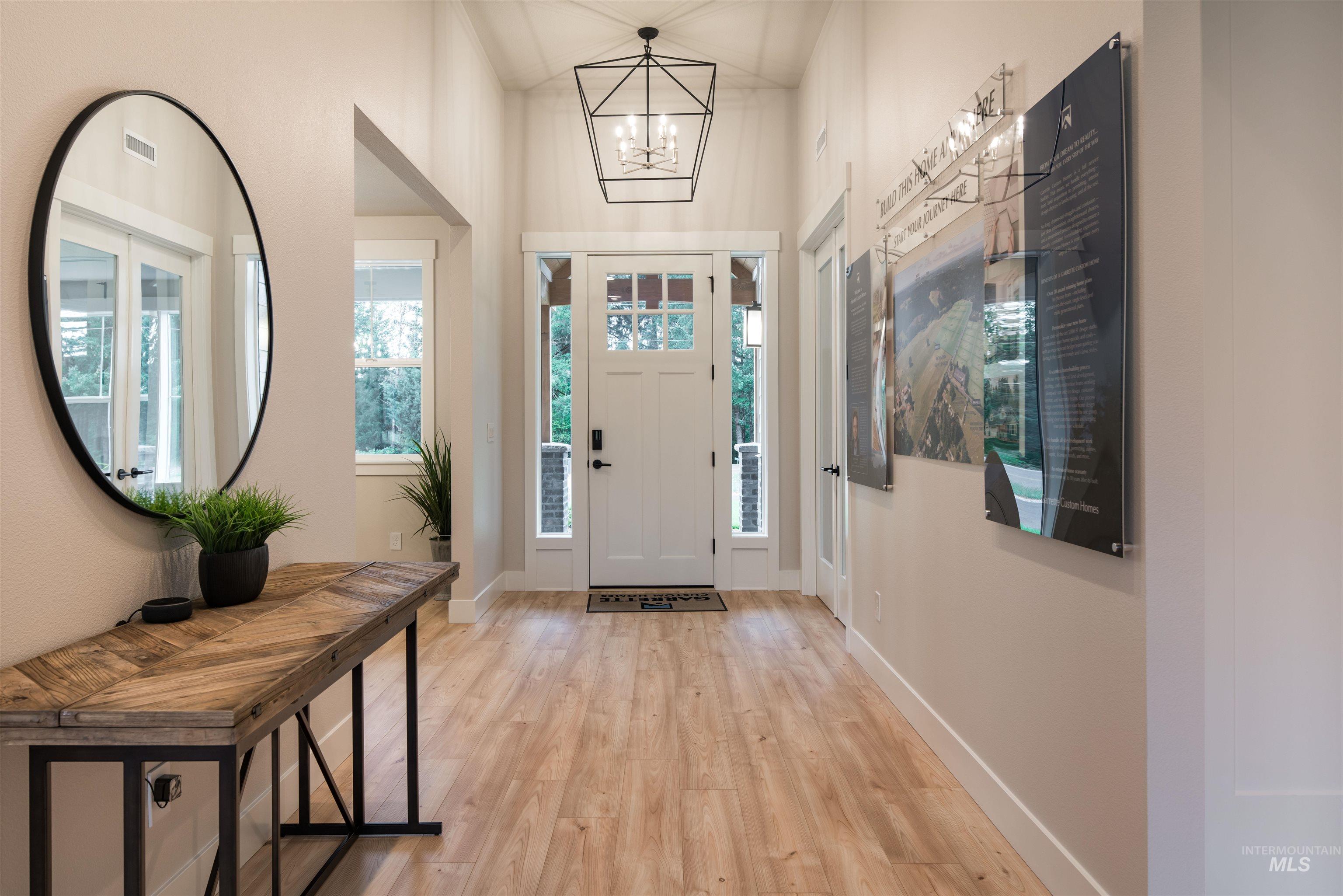 Entryway featuring light wood-type flooring and a chandelier