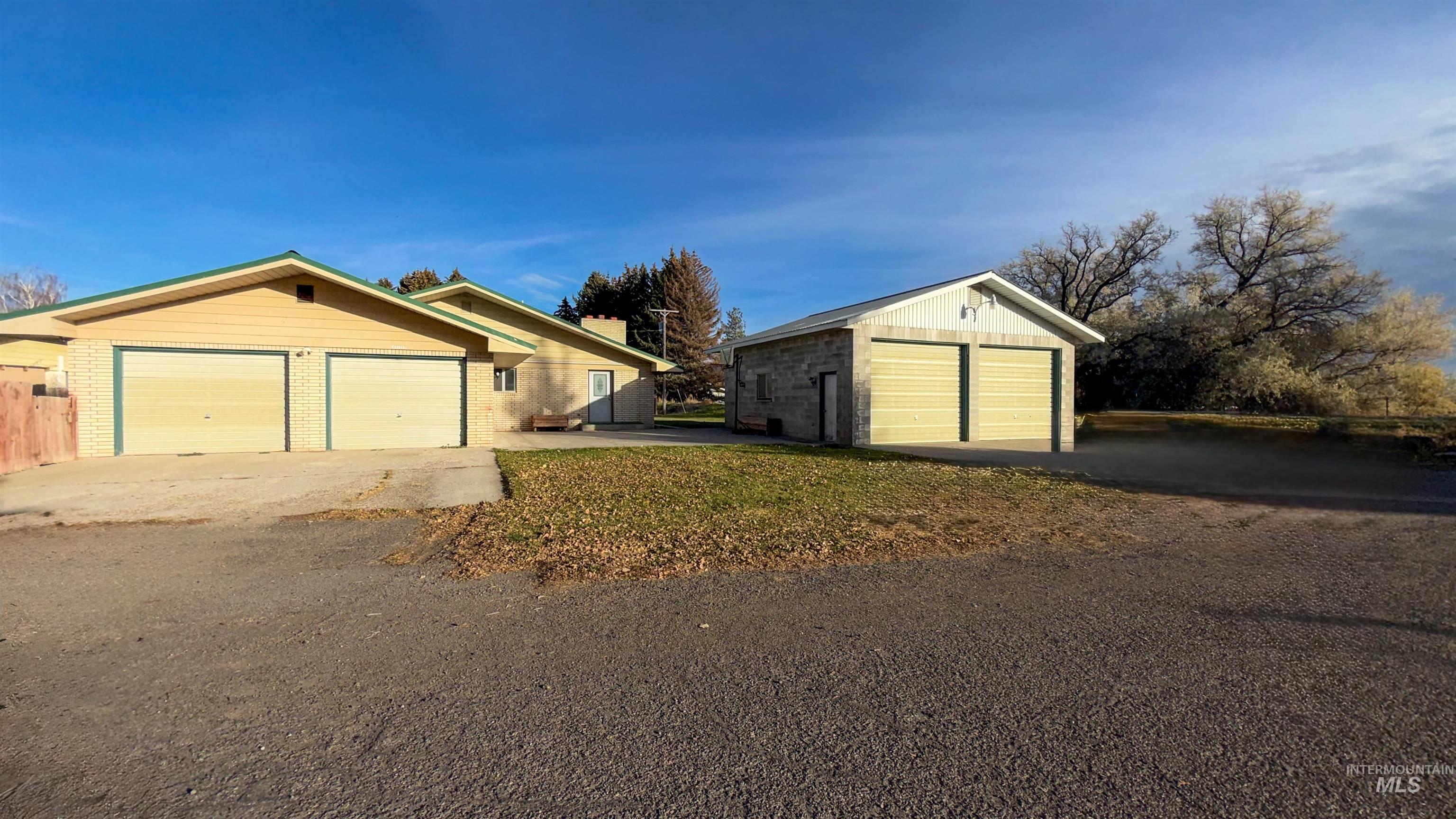 View of property exterior featuring an outbuilding, a garage, and brick siding