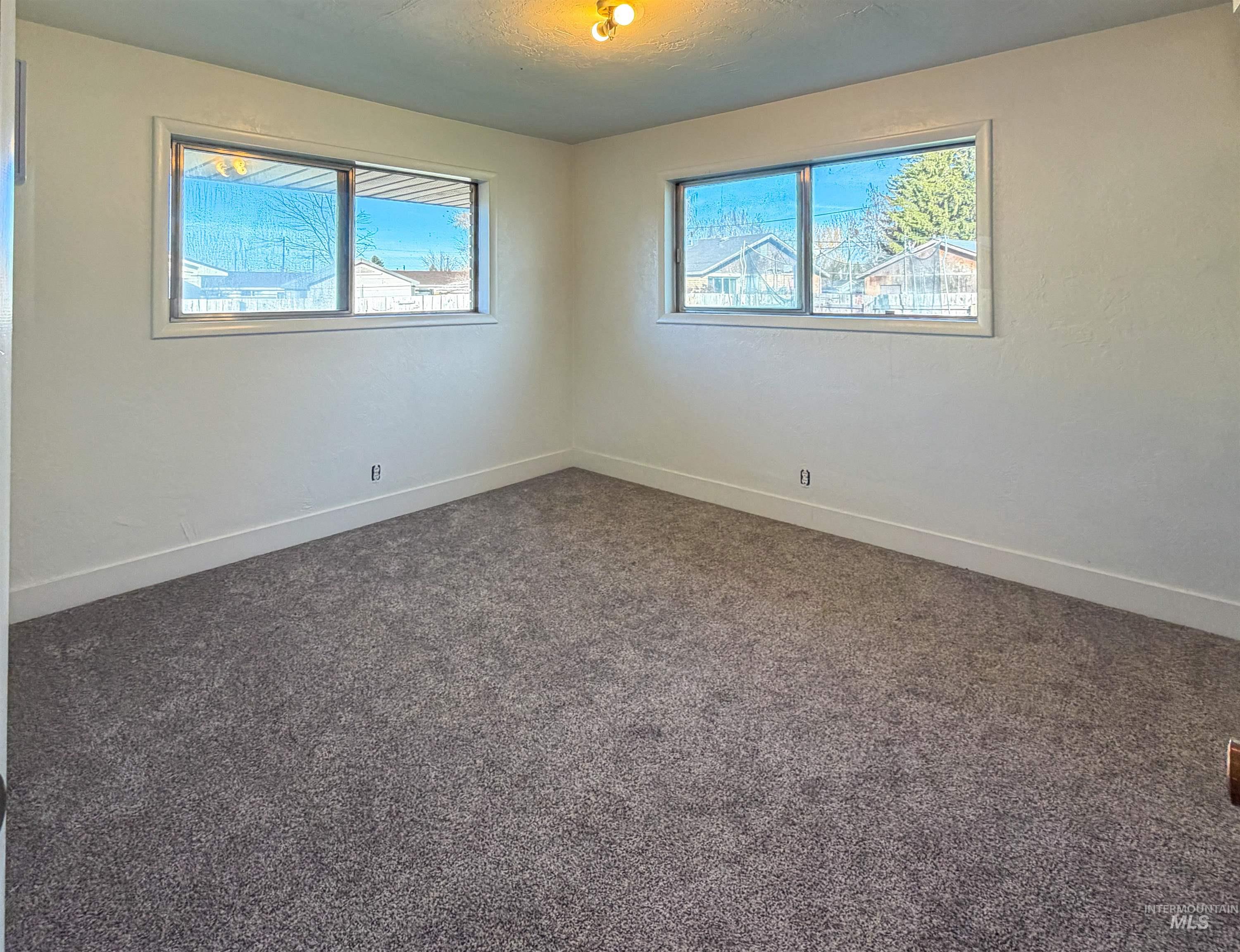 Spare room with dark colored carpet and a textured ceiling