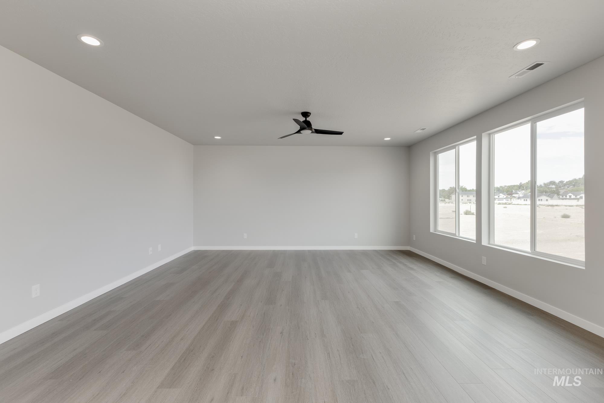 Empty room with light wood-style flooring, recessed lighting, and a ceiling fan