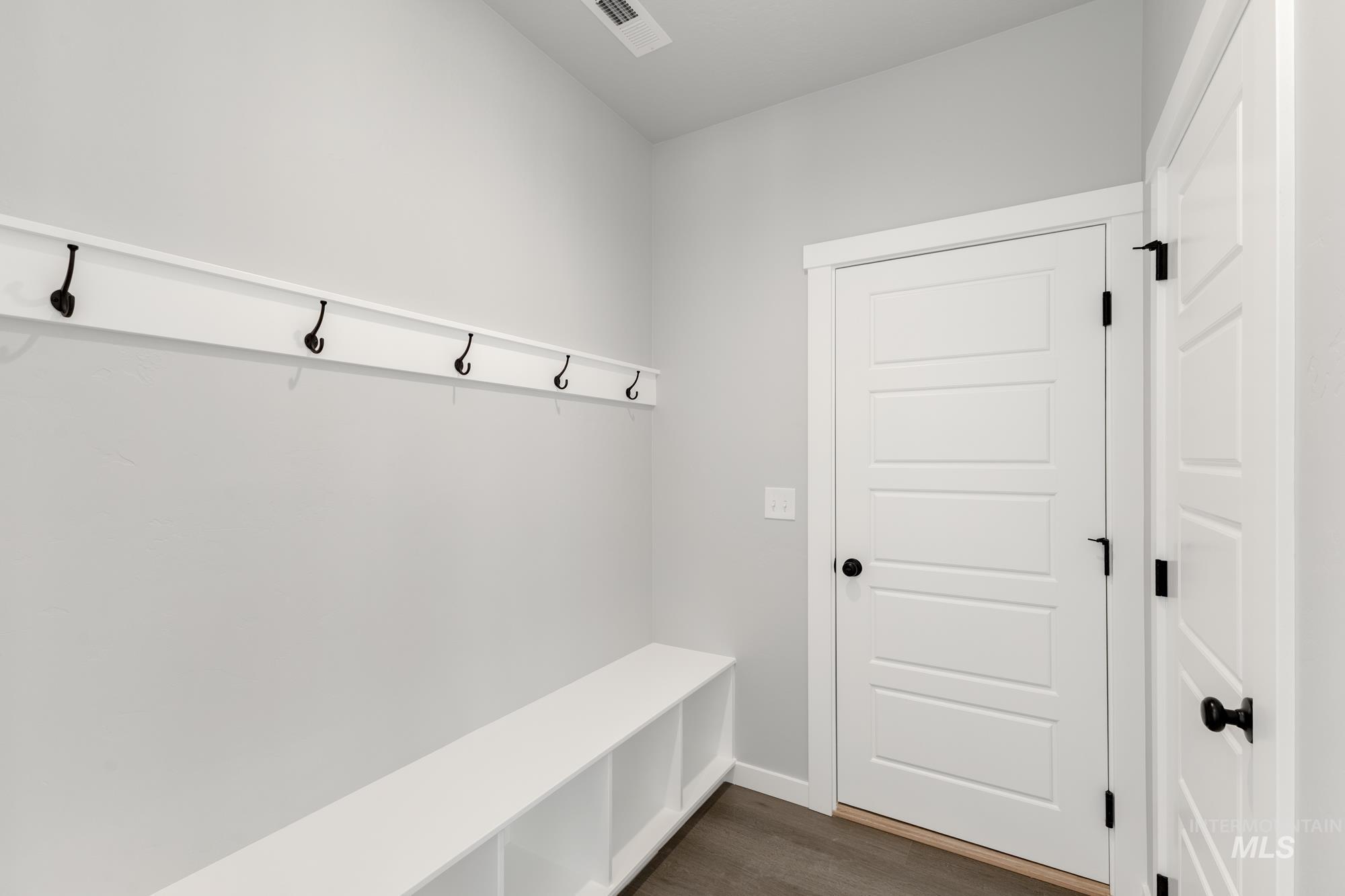 Mudroom featuring dark wood-style floors and baseboards