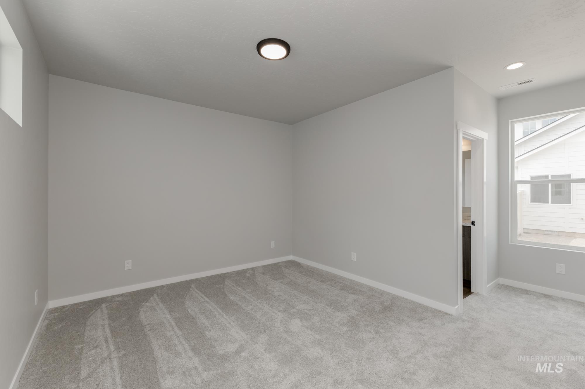 Spare room with light colored carpet and recessed lighting