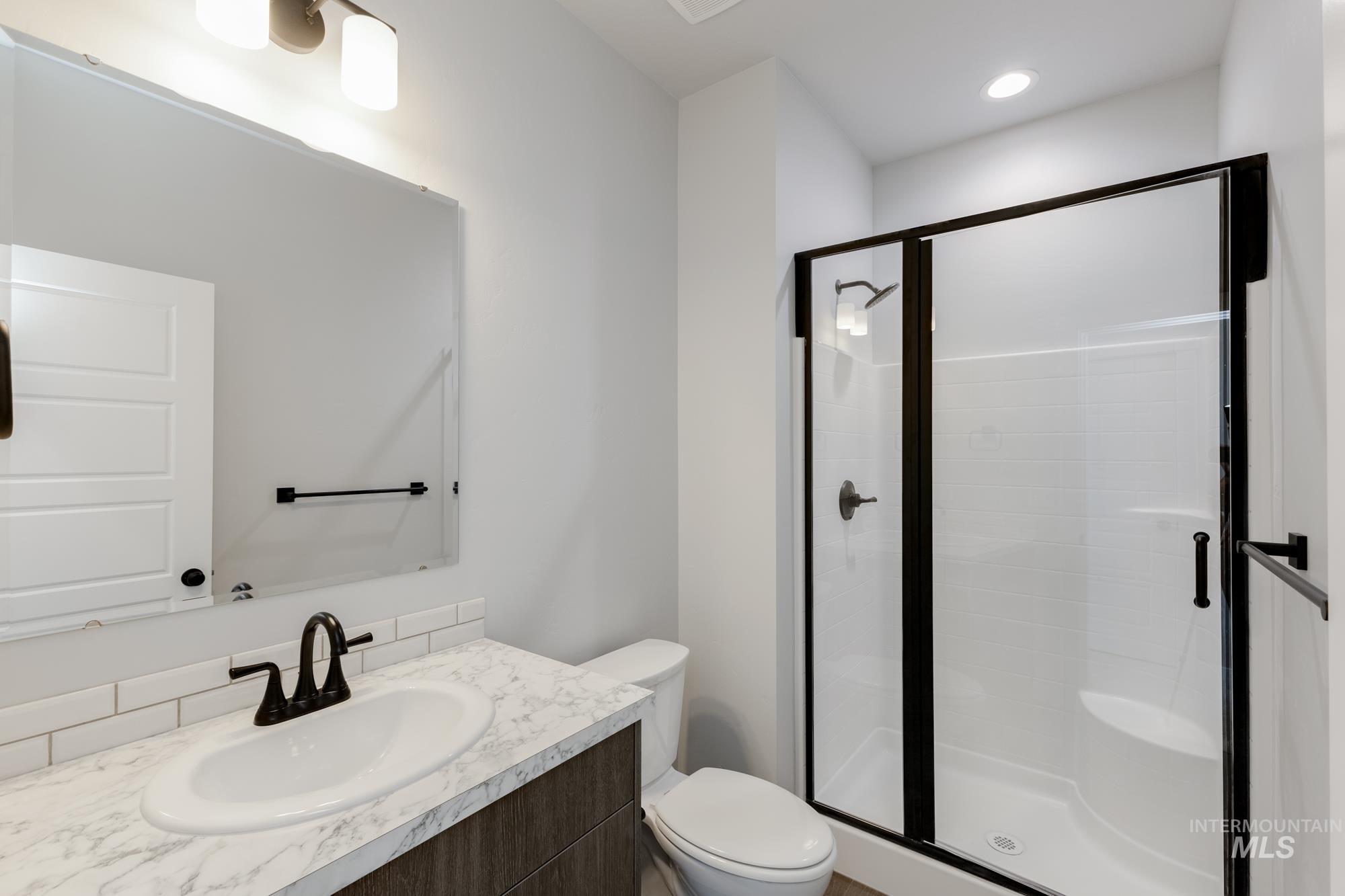 Bathroom featuring a stall shower and vanity