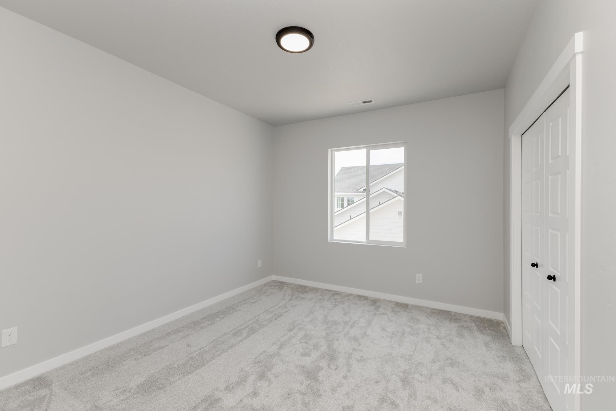 Unfurnished bedroom featuring light carpet and a closet