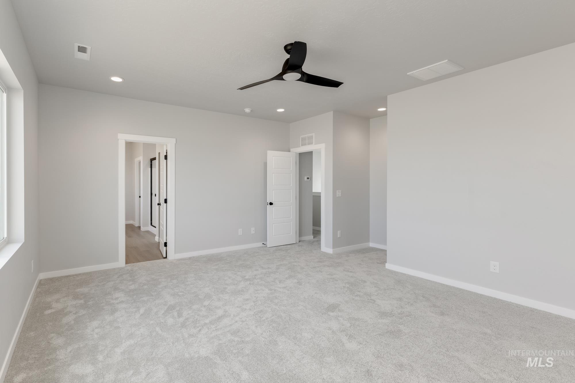 Unfurnished bedroom featuring light colored carpet, ceiling fan, and recessed lighting