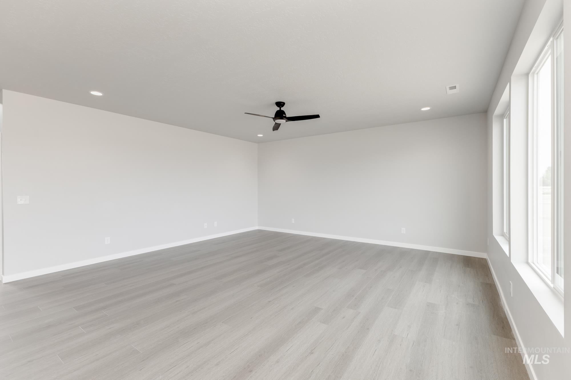 Unfurnished room with light wood-type flooring, a ceiling fan, and recessed lighting