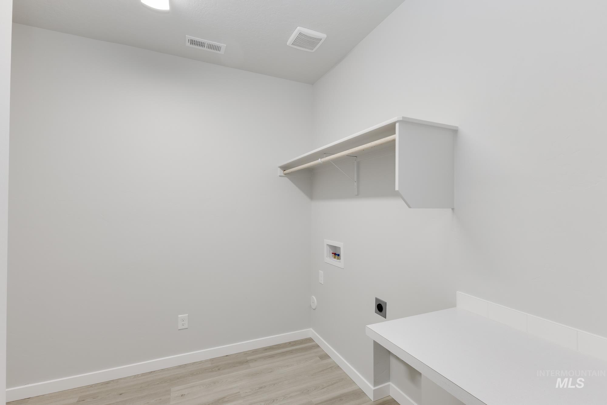 Washroom featuring hookup for an electric dryer, light wood-style flooring, and hookup for a washing machine