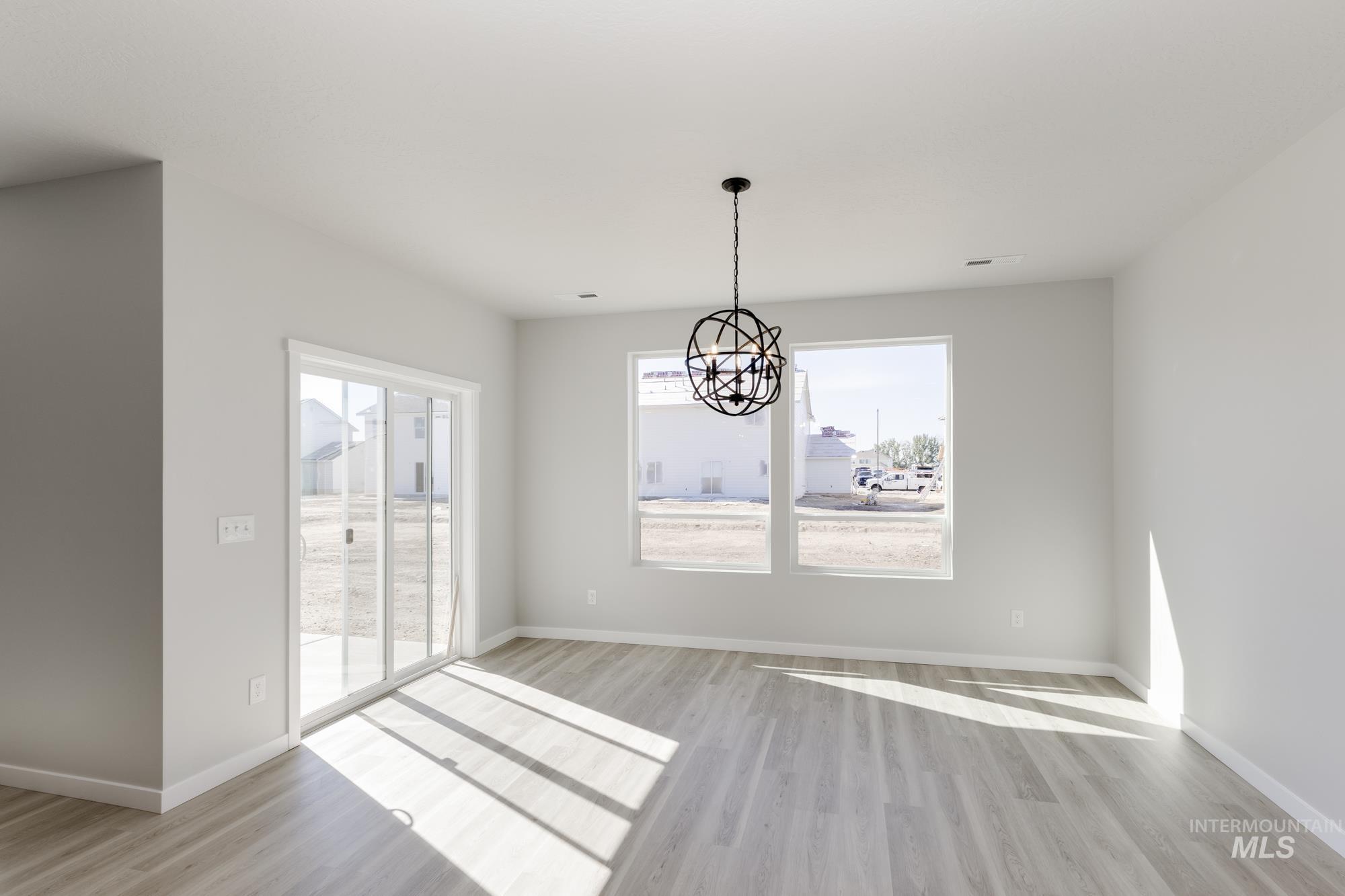 Unfurnished dining area featuring light wood-style flooring and a chandelier