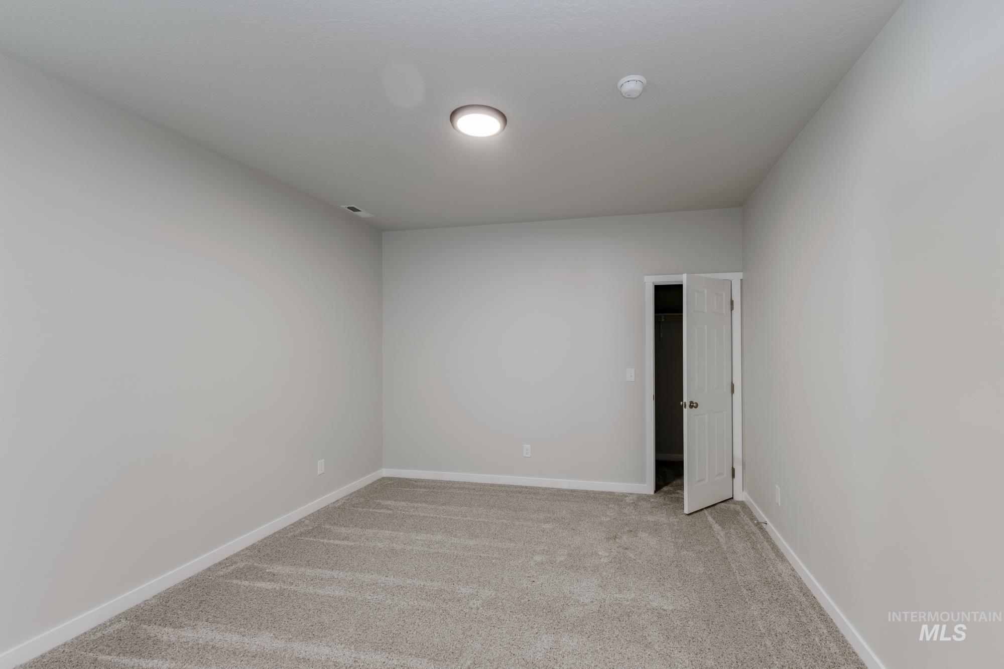 Spare room with light colored carpet and baseboards