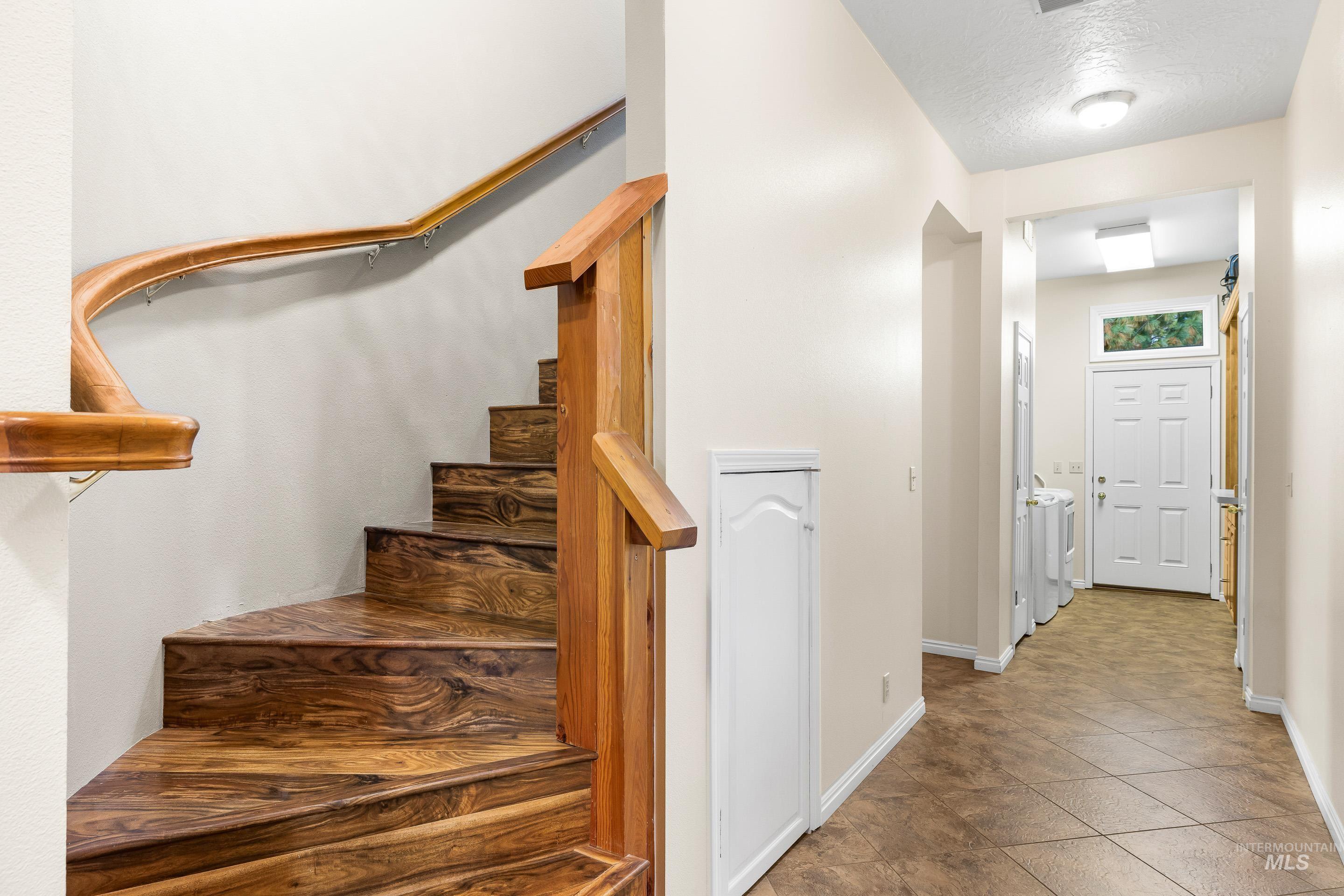 Stairs with a textured ceiling and tile patterned flooring