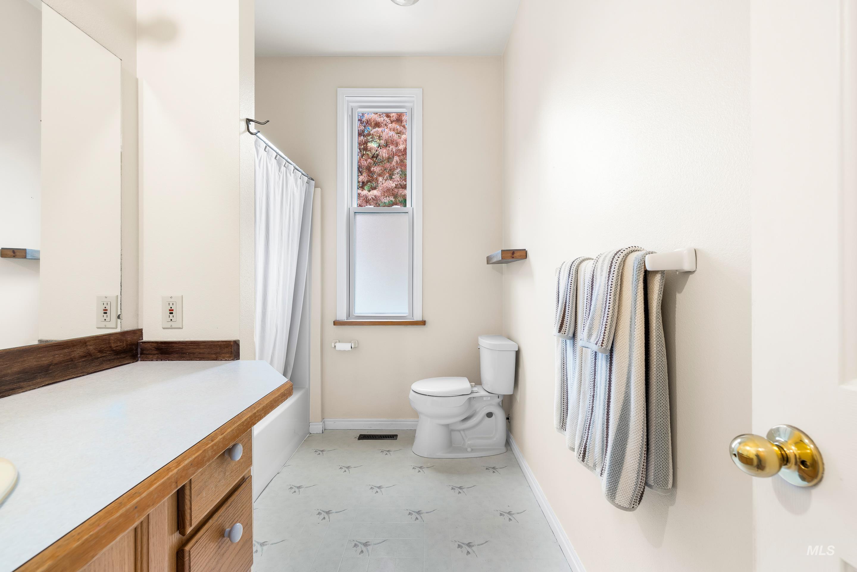 Full bath featuring light flooring, vanity, and shower / tub combo with curtain