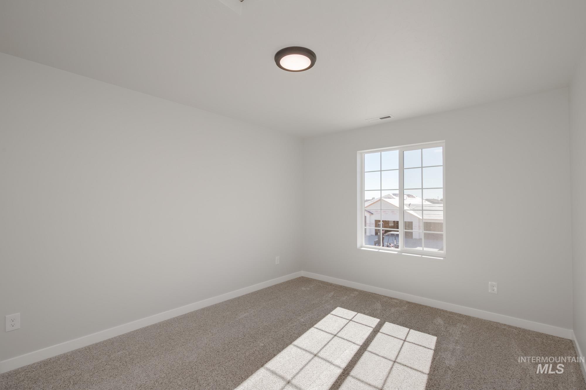 Carpeted empty room with baseboards