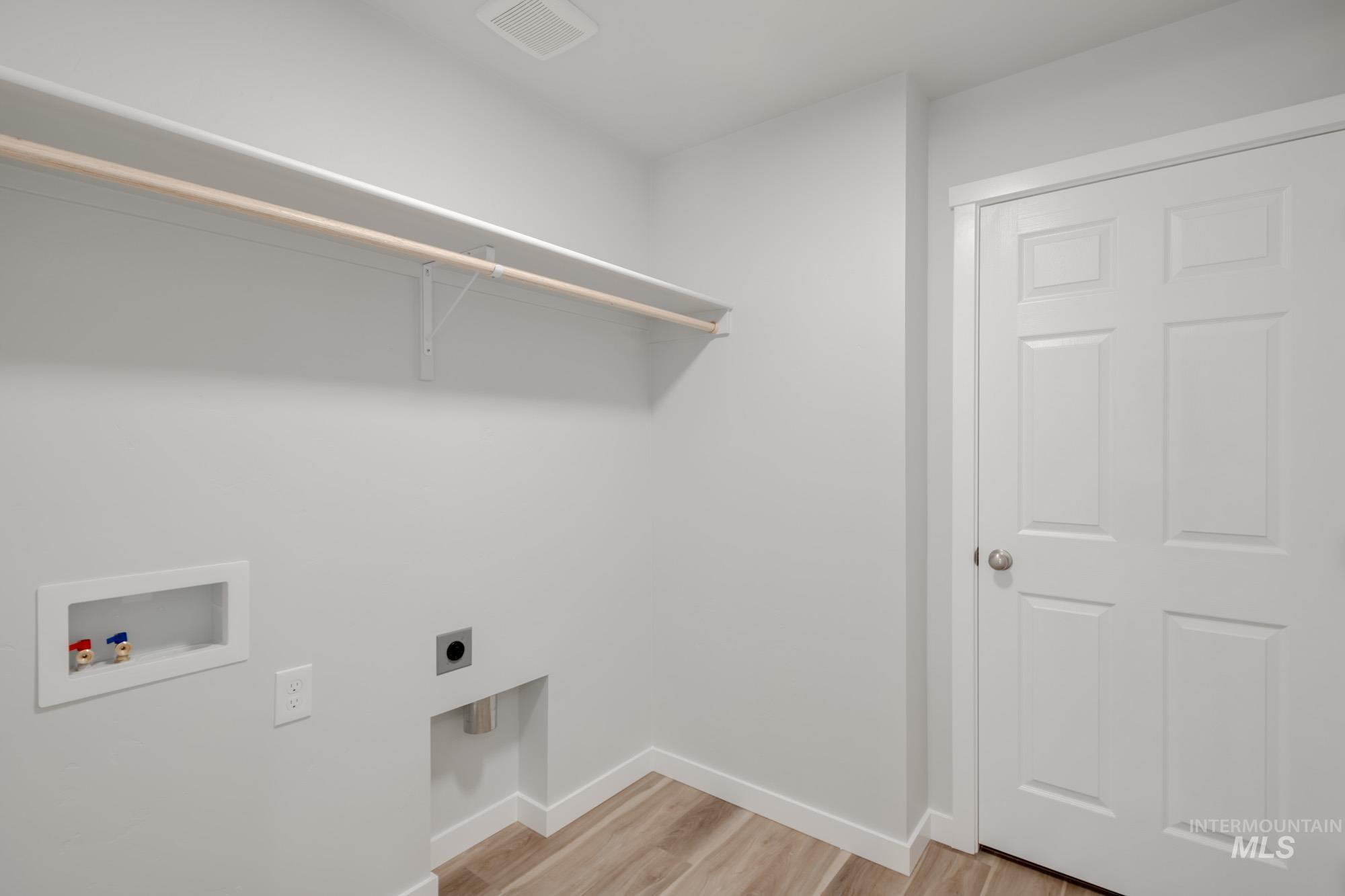 Laundry area featuring light wood-type flooring, washer hookup, and hookup for an electric dryer