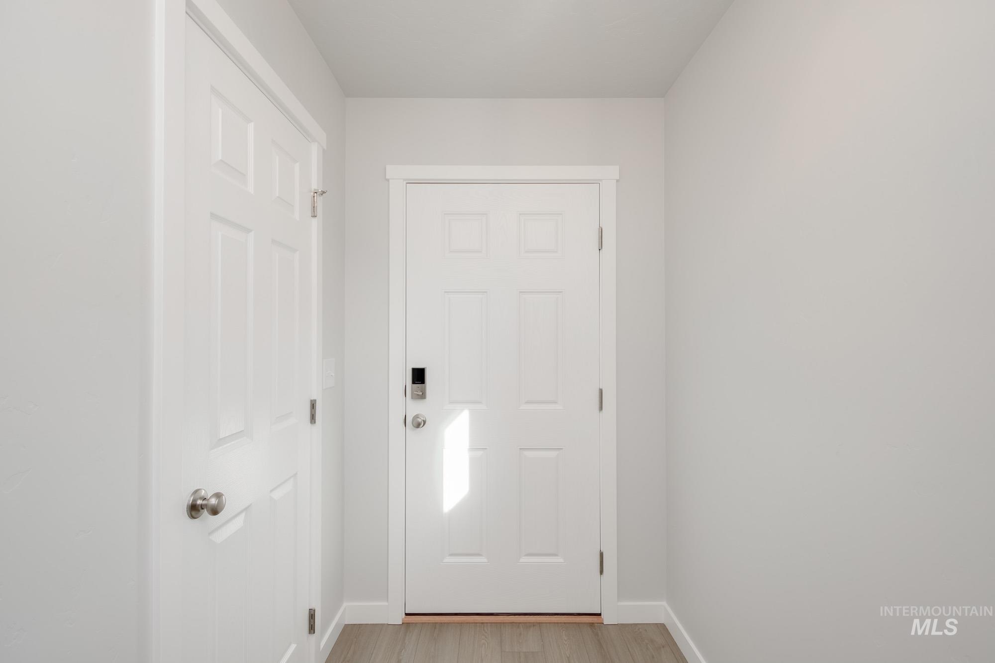 Doorway to outside with baseboards and wood finished floors