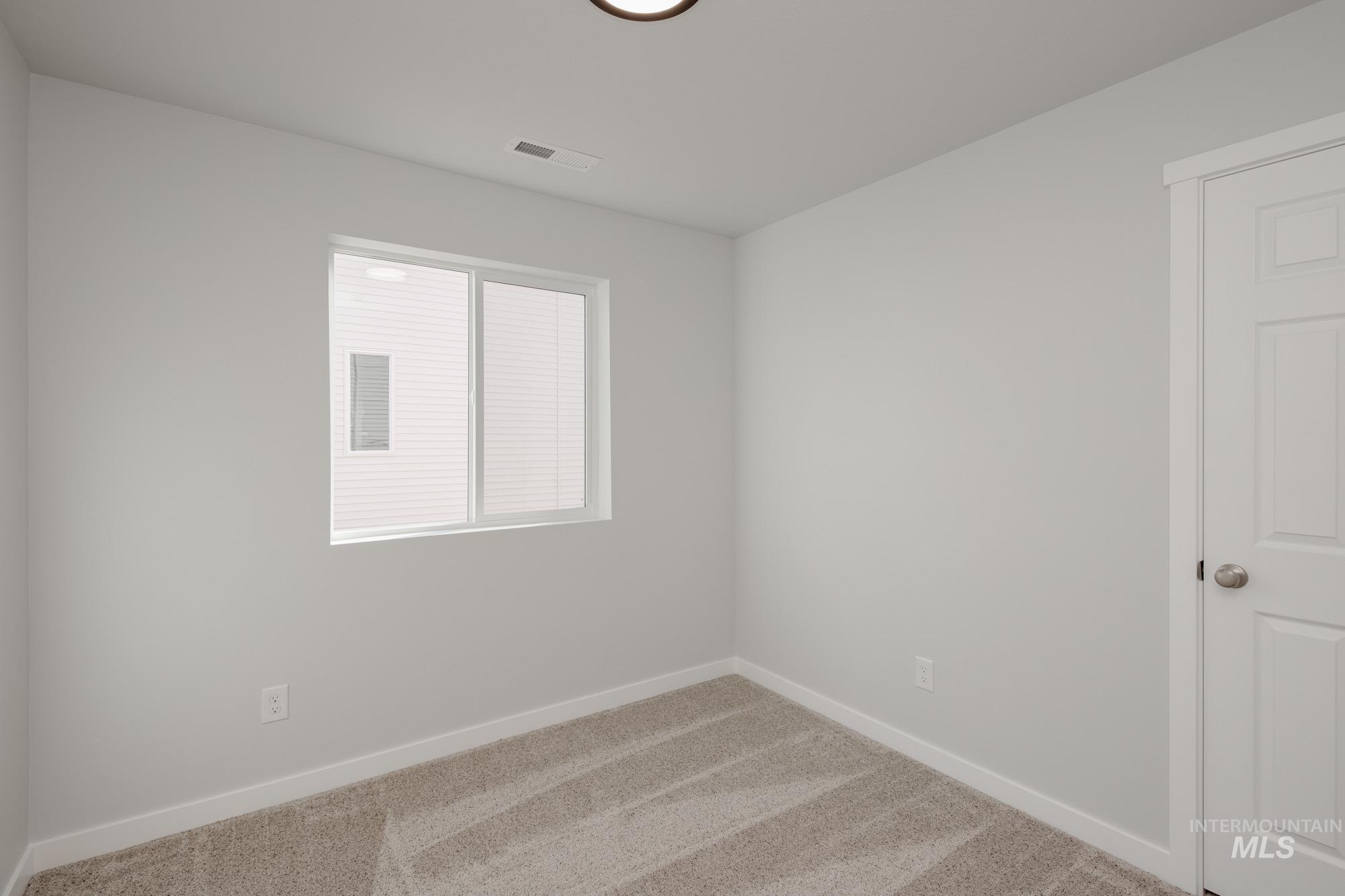 Spare room featuring carpet floors and baseboards