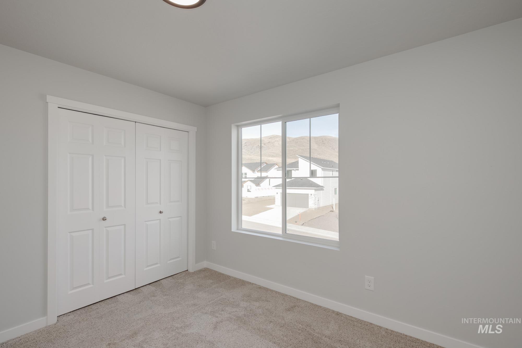 Unfurnished bedroom with light carpet and a closet