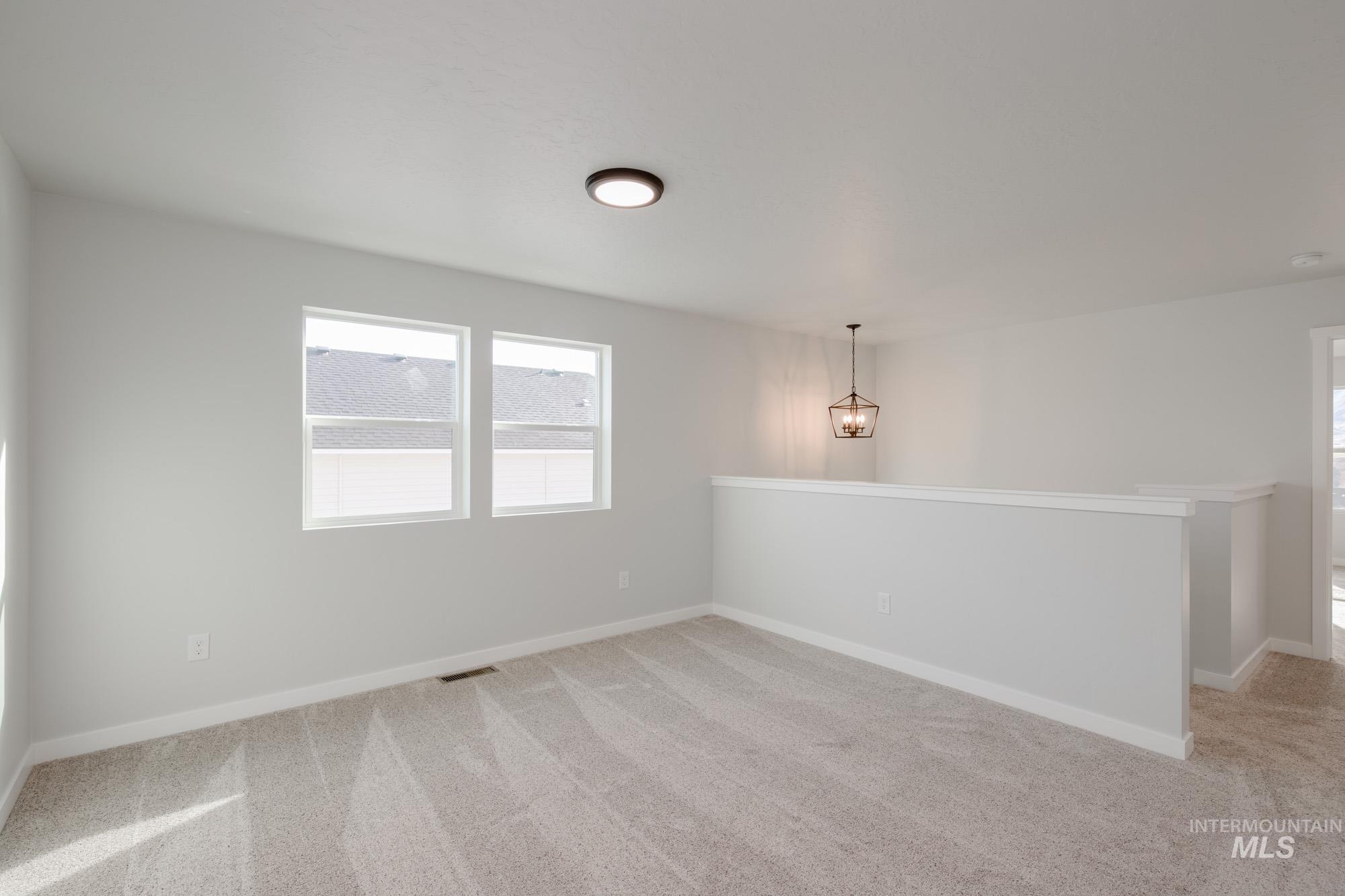 Empty room featuring light carpet and plenty of natural light