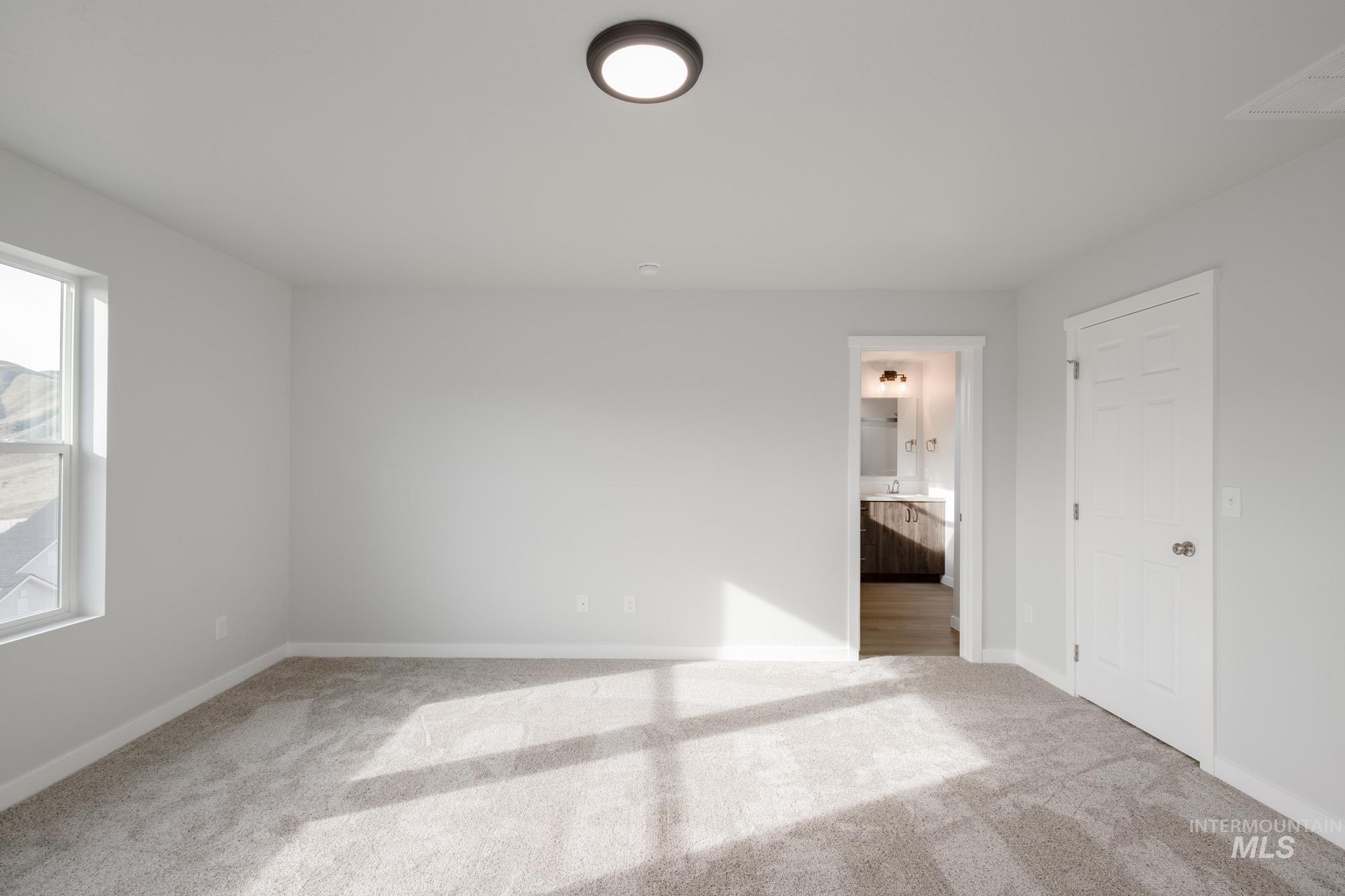 Unfurnished bedroom featuring carpet floors and ensuite bathroom