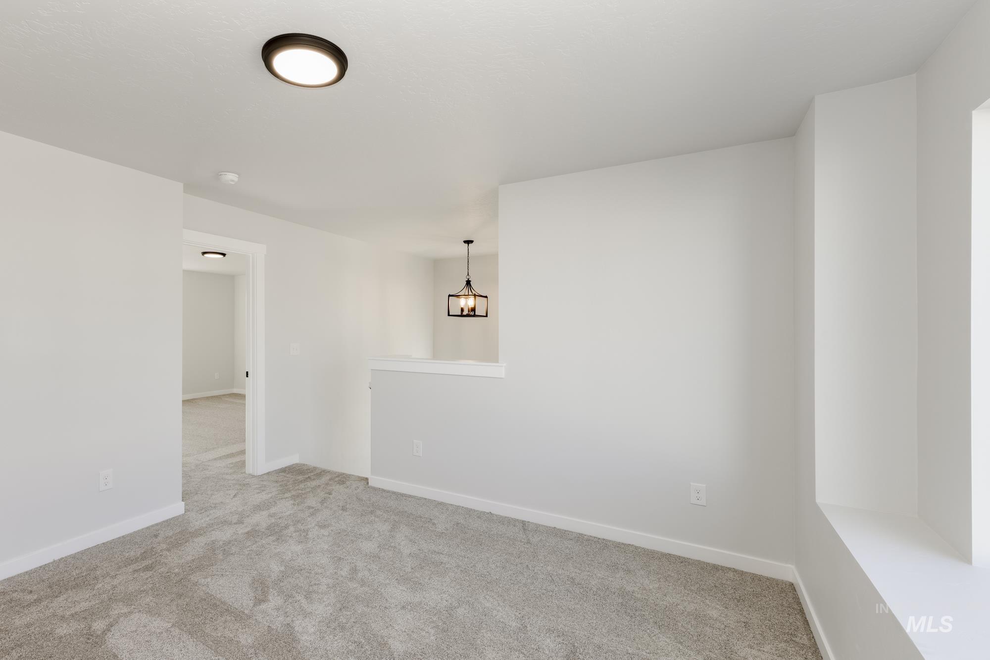 Carpeted empty room featuring baseboards
