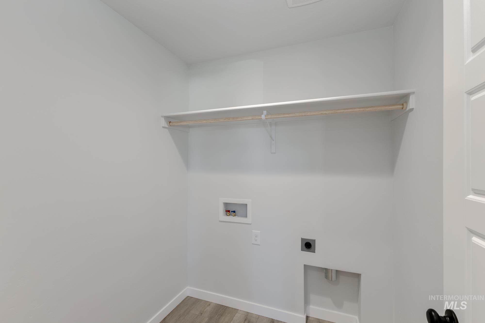 Laundry room with light wood finished floors, hookup for a washing machine, and electric dryer hookup