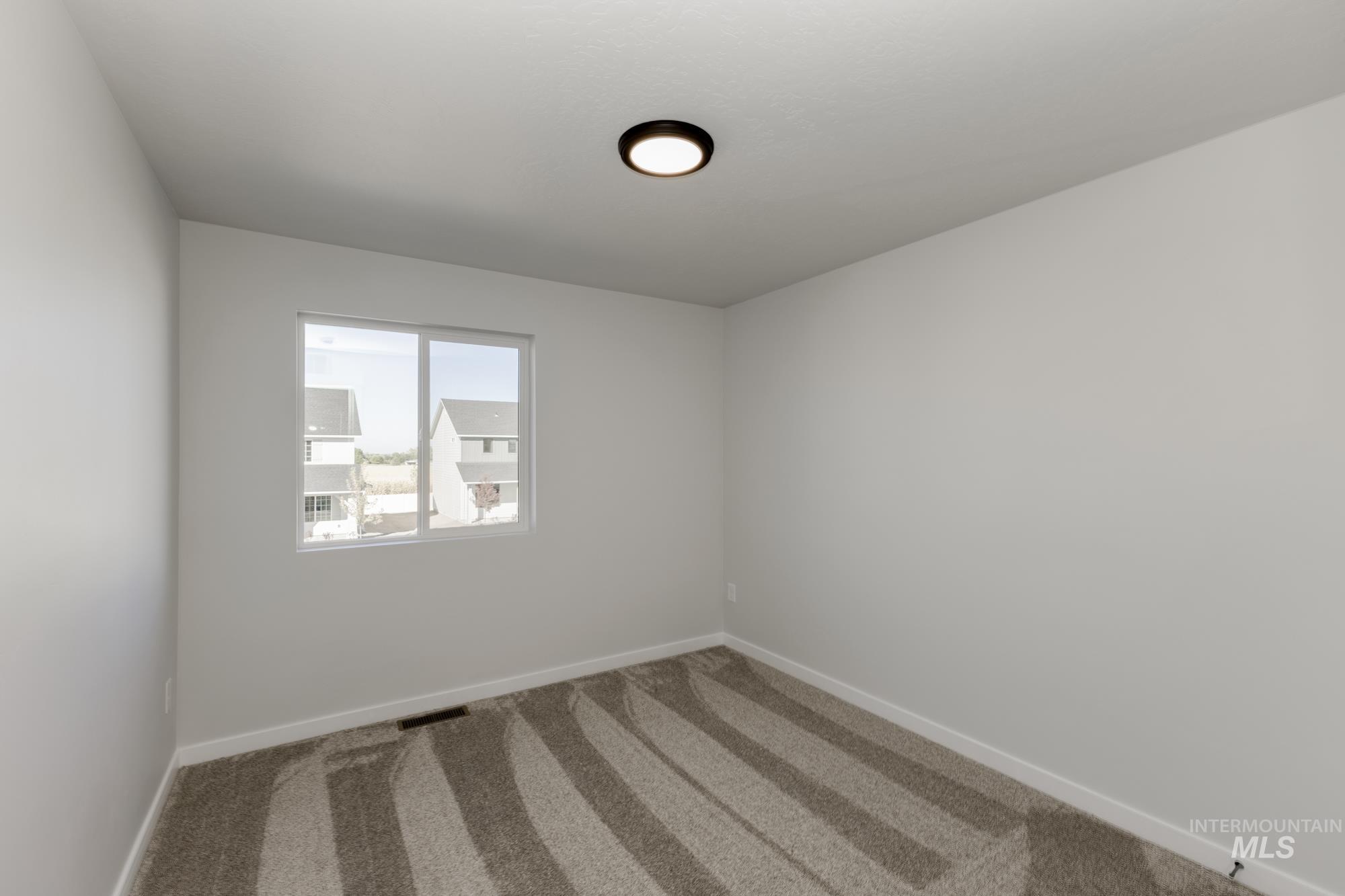 Carpeted spare room with baseboards