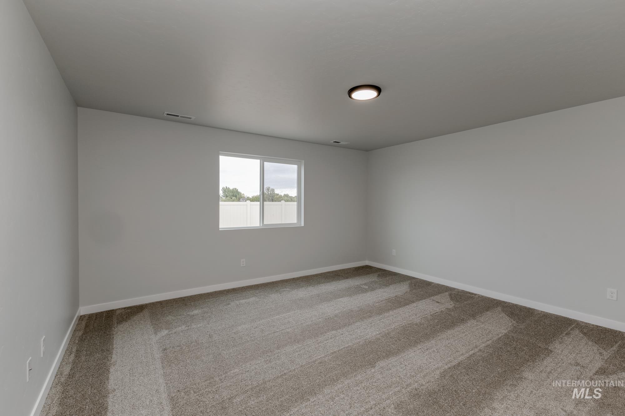 Unfurnished room featuring light colored carpet and baseboards