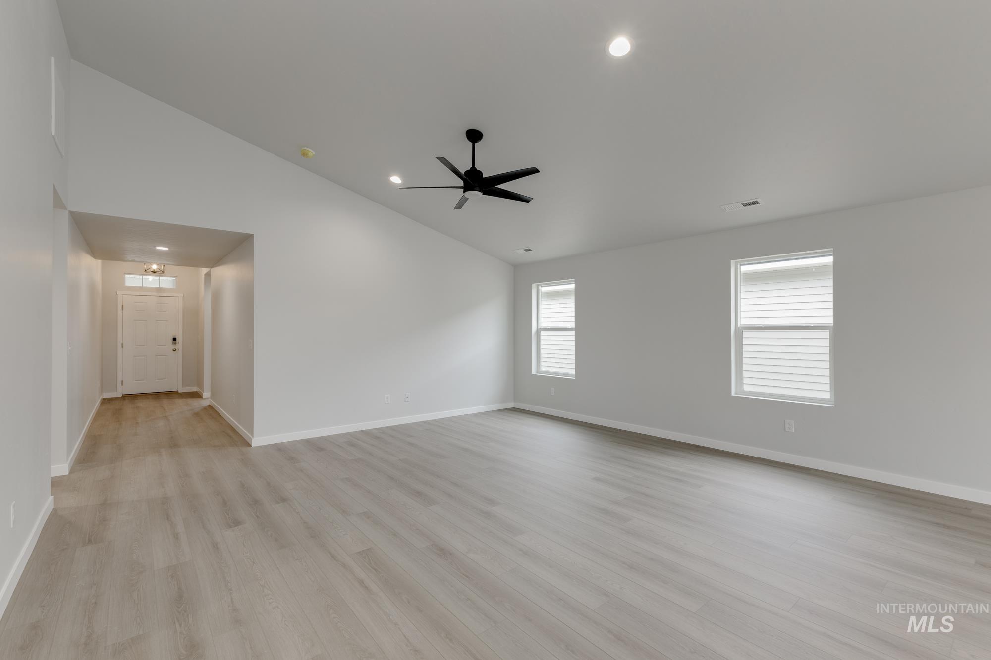 Spare room featuring vaulted ceiling, light wood-style flooring, recessed lighting, and ceiling fan