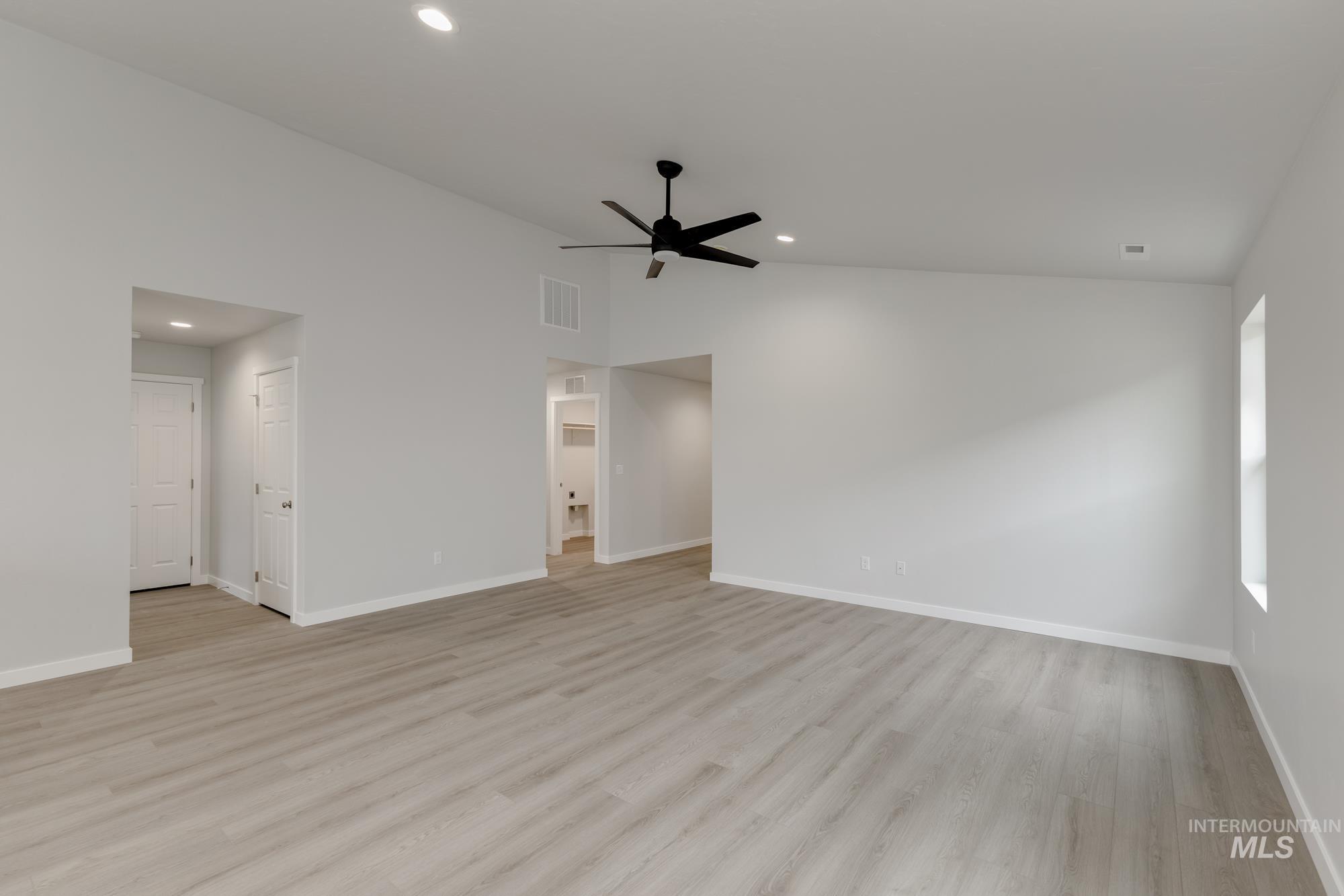 Empty room featuring vaulted ceiling, light wood finished floors, recessed lighting, and ceiling fan