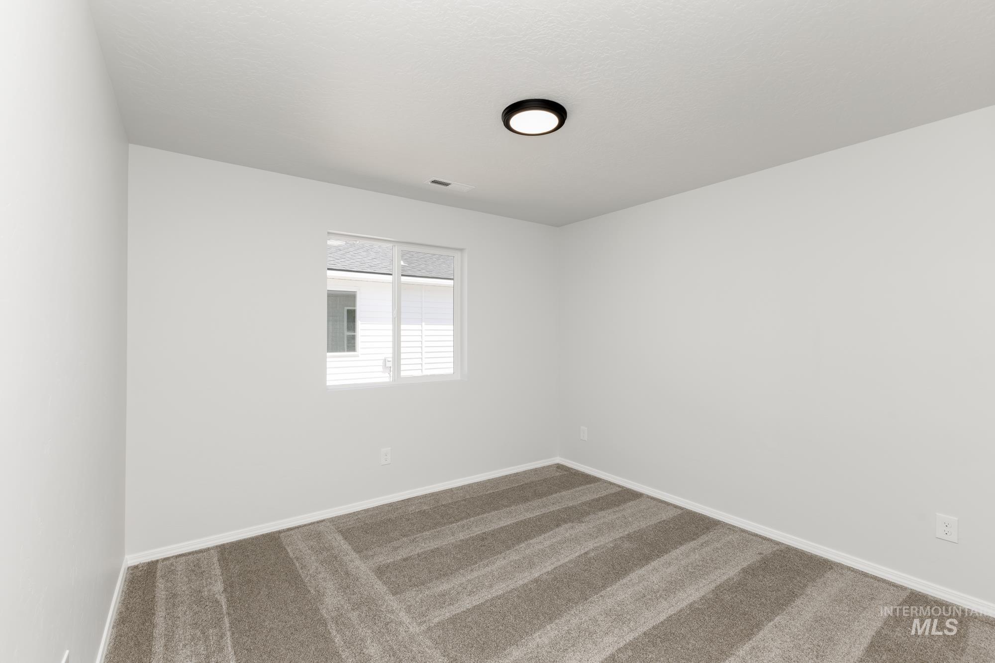 Carpeted empty room featuring baseboards