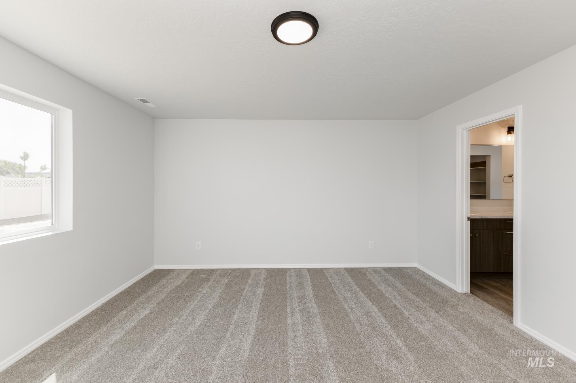 Empty room featuring light carpet and baseboards