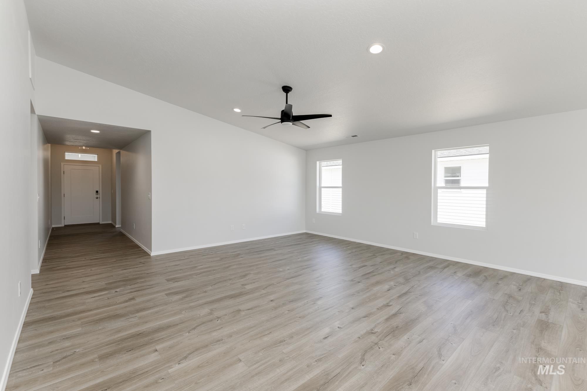 Unfurnished room featuring light wood-style flooring, recessed lighting, vaulted ceiling, and a ceiling fan