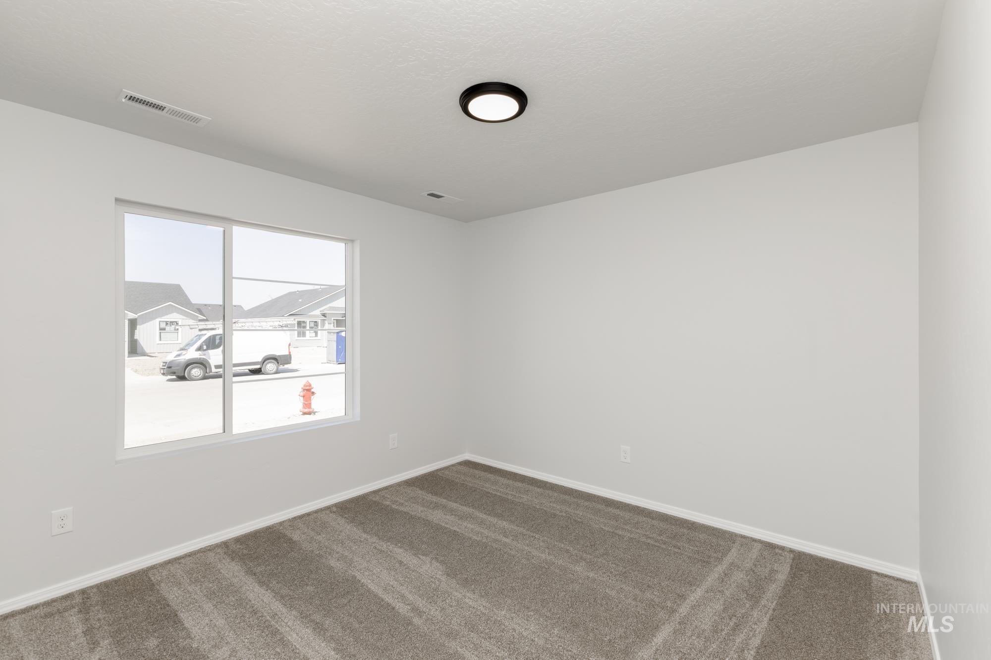 Carpeted spare room with baseboards