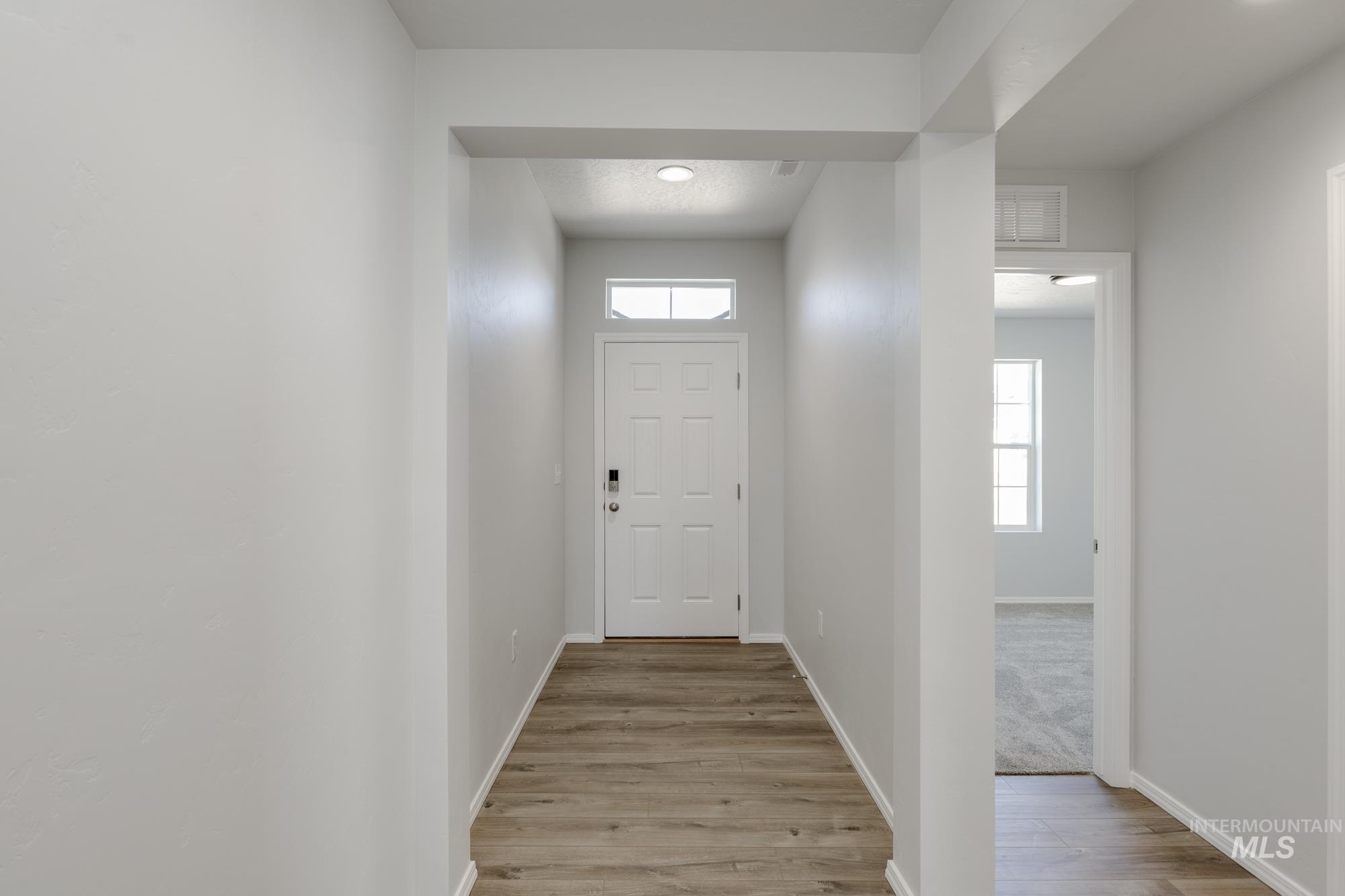 Entryway with plenty of natural light and wood finished floors