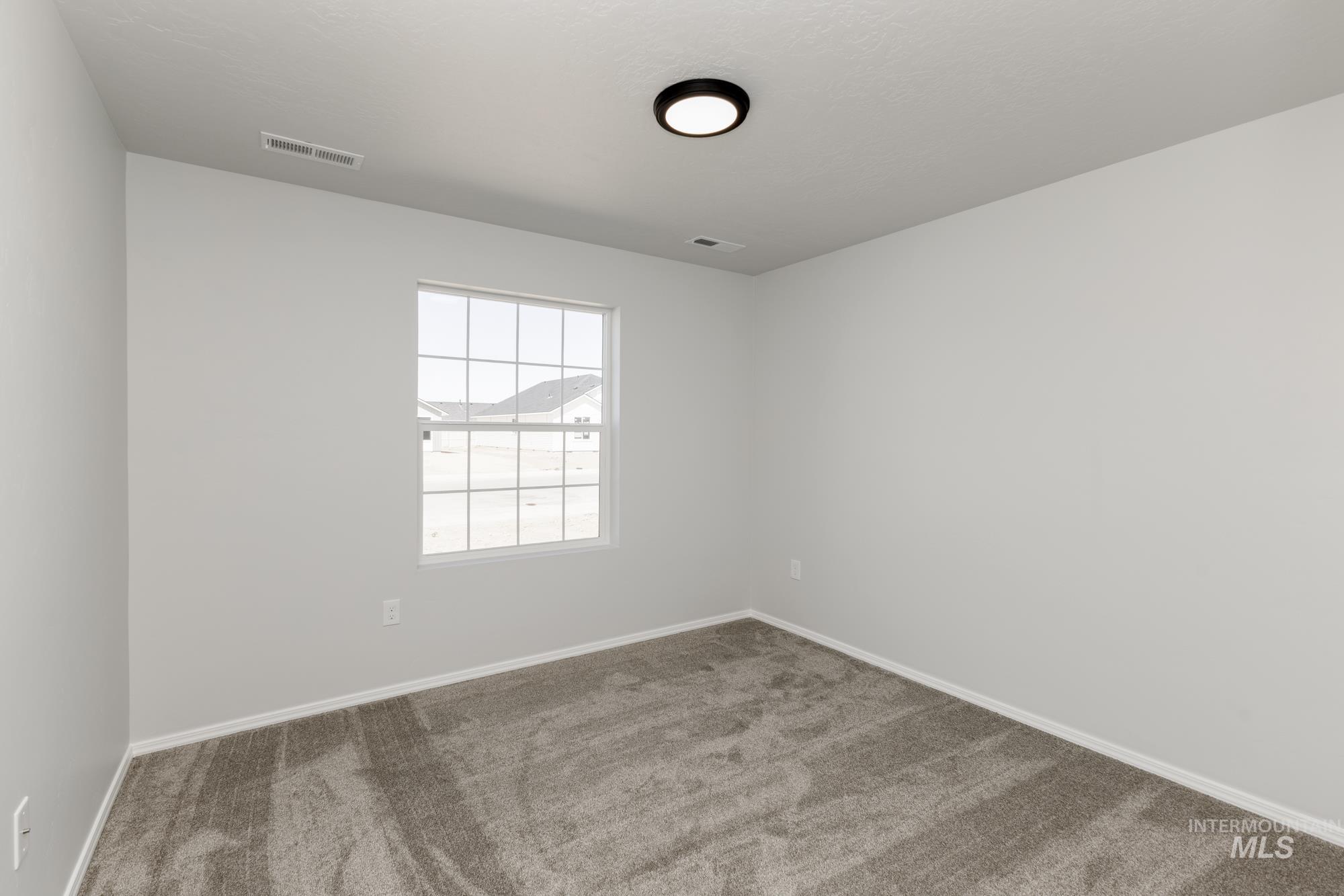 Carpeted empty room featuring baseboards