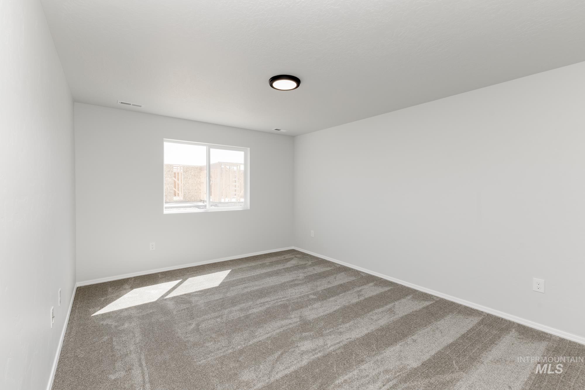 Carpeted spare room with baseboards