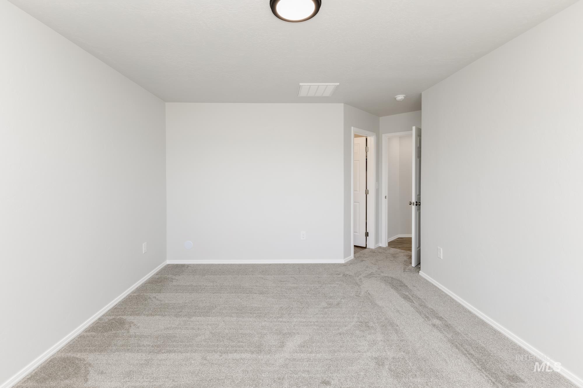 Unfurnished room with light colored carpet and baseboards